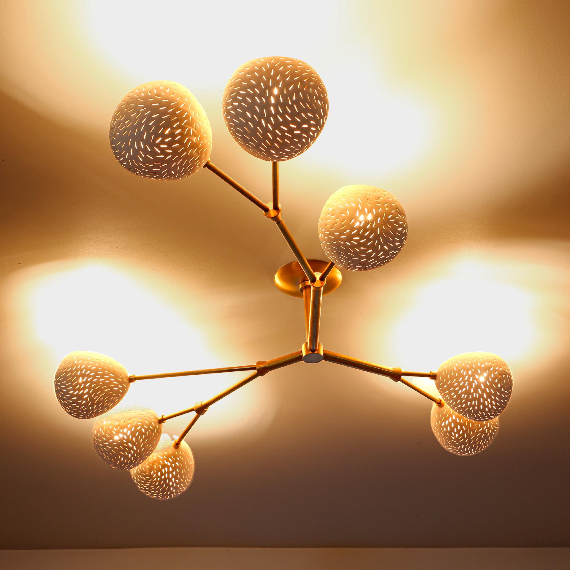 Diseñado especialmente para techos bajos, este escultural accesorio de iluminación con brillos, cae a sólo 9 pulg. del techo. Proporciona una suave luz indirecta desde unas pantallas que están abiertas hacia el techo, aunque pueden girarse y quedar