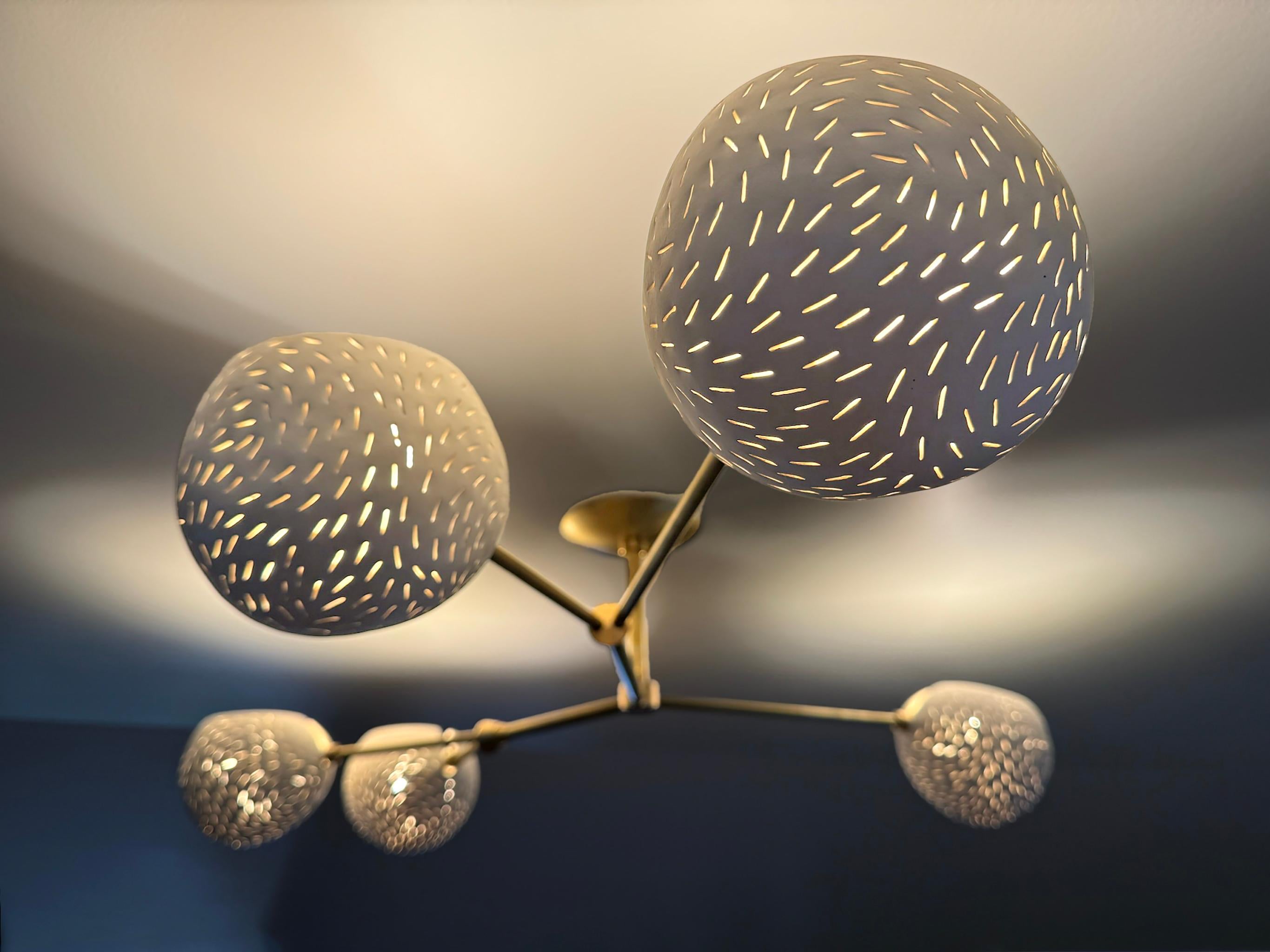 Conçu spécialement pour les plafonds bas, ce luminaire sculptural avec bling bling ne tombe qu'à 9 pouces du plafond. Il fournit une lumière douce et indirecte grâce à des abat-jour ouverts au plafond, mais qui peuvent être tournés vers le bas si on