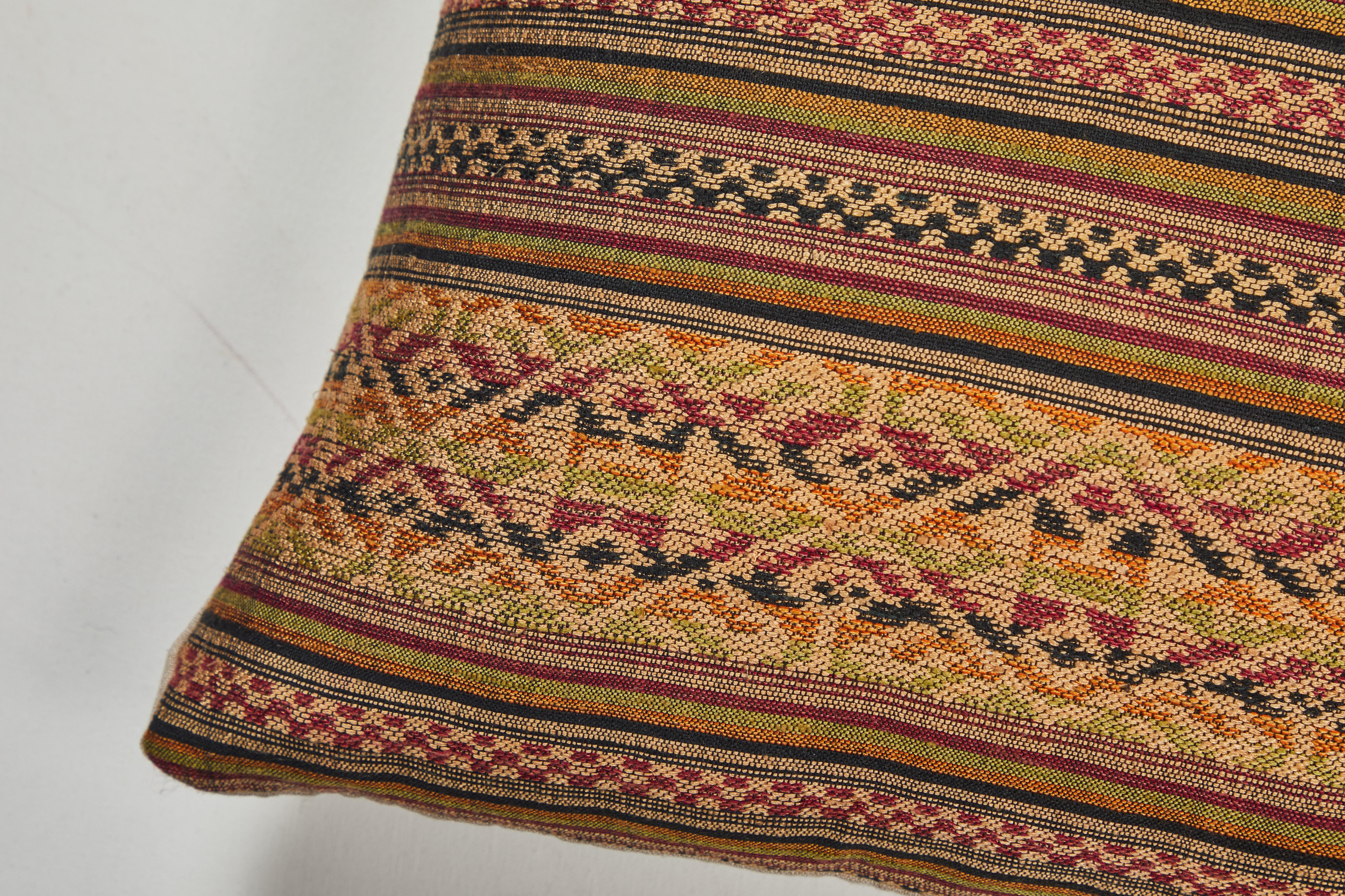 Supplementary weft technique handwoven textile. Green, gold, orange, red, black and raw silk.