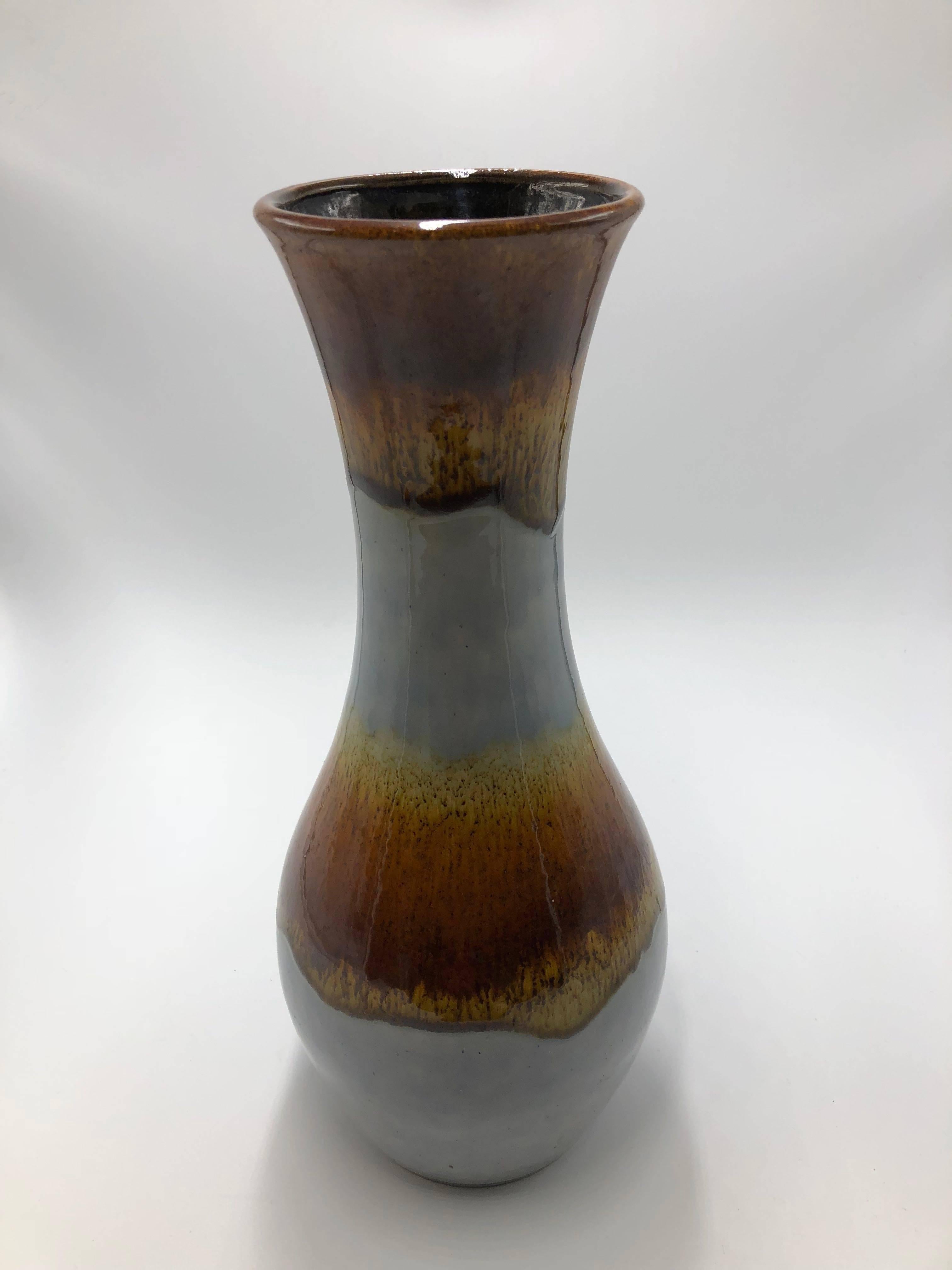 Elegant, long-necked vase in a flowing glaze going from brown and gold lava like designs to pale blue. There is some cracking in the blue.

Bottom mark: 1410/30

Measures: Height 30 cm - 11.8