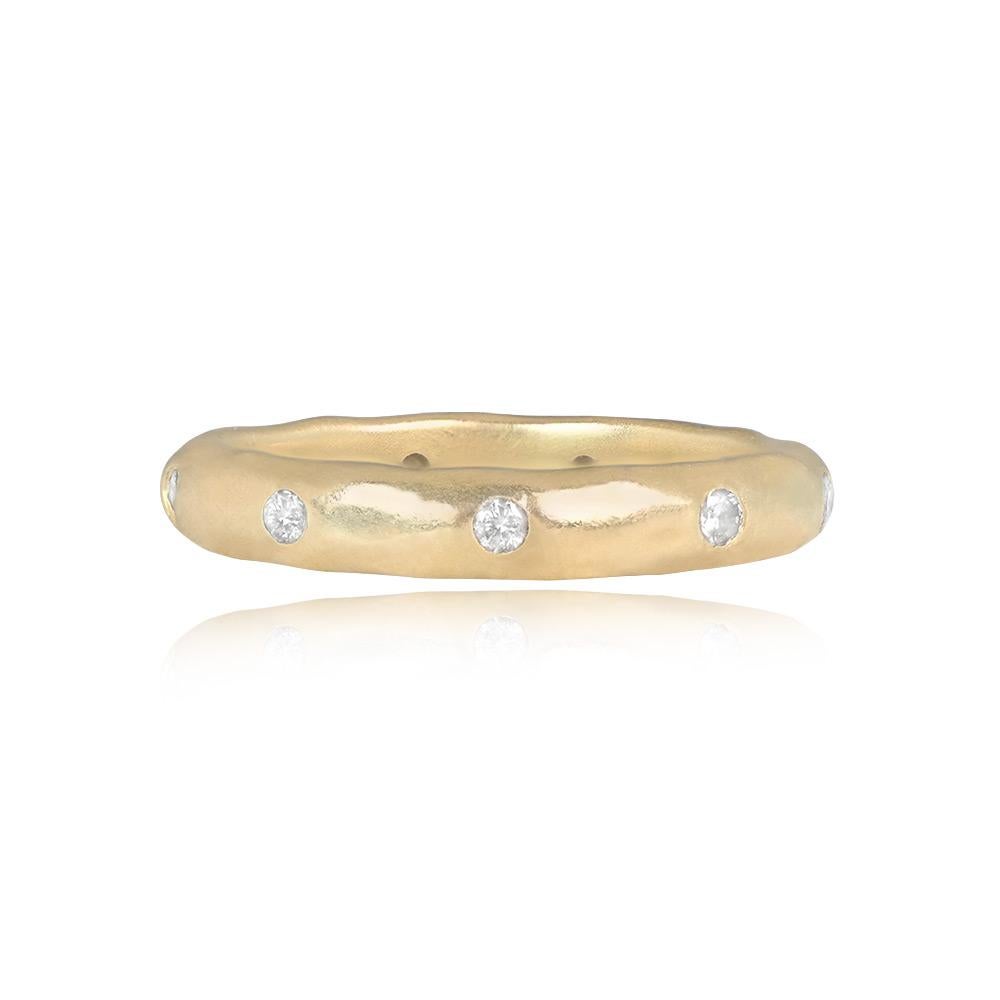 A stunning vintage wedding band meticulously crafted in 14k hammered yellow gold. Adorned with round brilliant cut diamonds, the band showcases a total diamond weight of approximately 0.15 carats. The unique combination of textured gold and