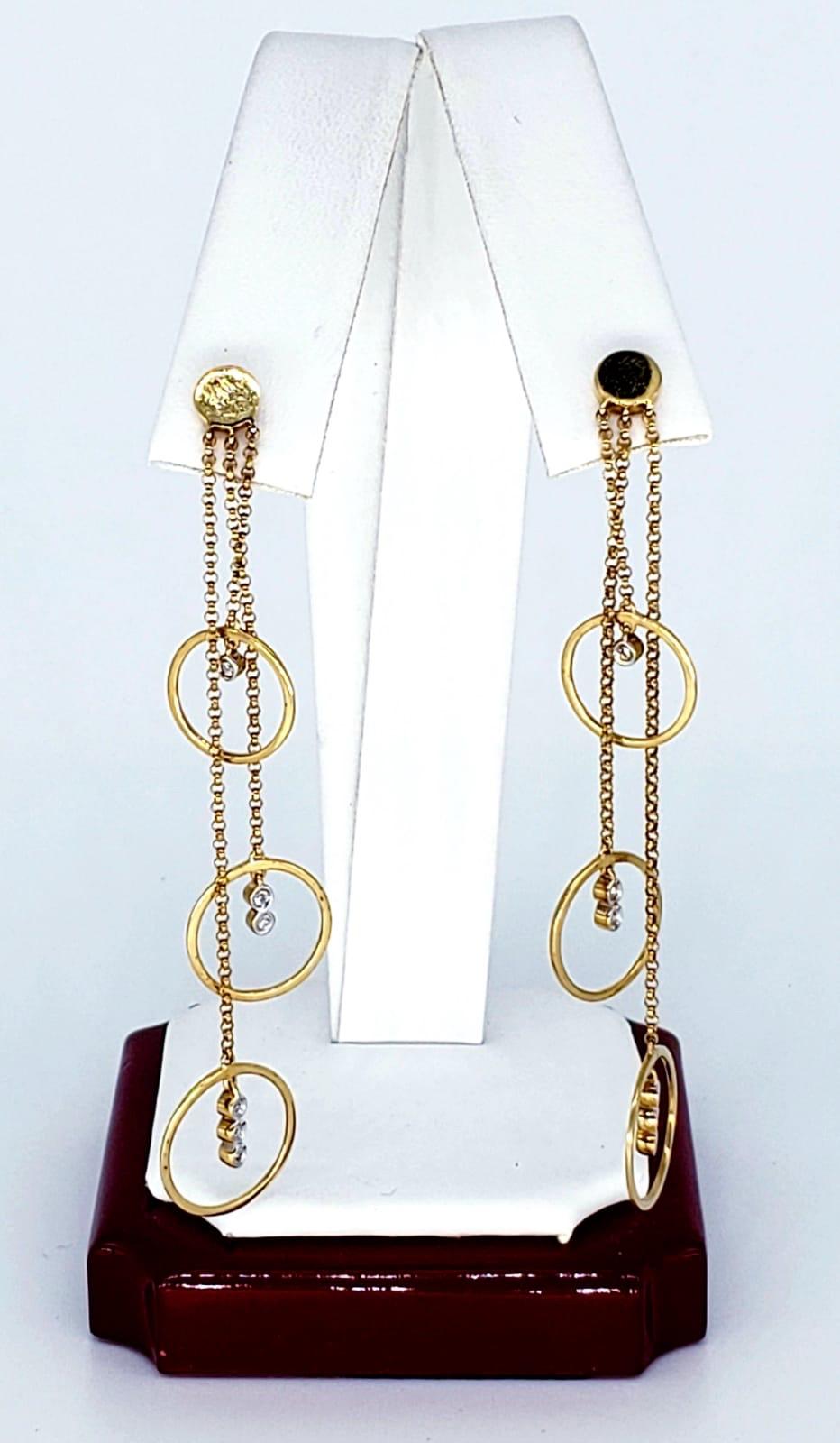 Vintage 0.24 Carat Diamond Dangling Hoop Design 14k Gold Earrings. The earrings feature 12 diamonds in total weighting approx 0.24 carats. The earrings are made from 14k solid gold & measure 11mm X 65mm and weights 3.5 grams 14k gold. Beautiful