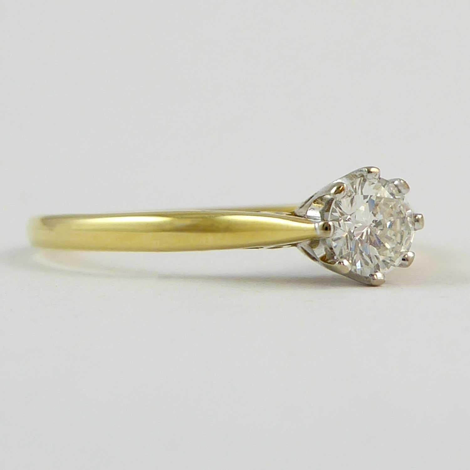 A vintage diamond ring from the 1980s being an eight-claw set brilliant cut diamond approx. 0.25ct and with assessed colour and clarity of I-J and SI2-I1 respectively.  In a white gold metal rex solitair mount to a yellow gold D shaped cross section