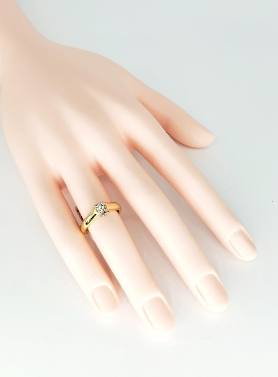 Vieille bague avec un diamant central de 0,26 carat G/VS en or 18k. La bague comporte une monture centrale en or blanc pour le diamant, tandis que le reste de la bague est en or massif 18 carats. La bague pèse 5,8 grammes et est une taille 5.
