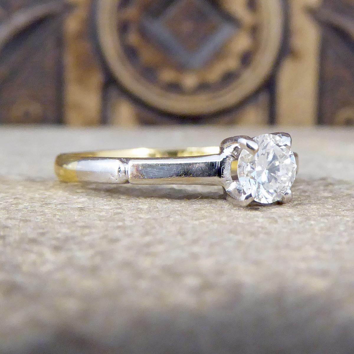 Featuring in this vintage ring is a clear and bright 0.35ct Round Cut Diamond in a White Gold four claw setting and plain shoulder leading down to a 18ct Yellow Gold plain band. This hand made ring is a true classic and would make the perfect