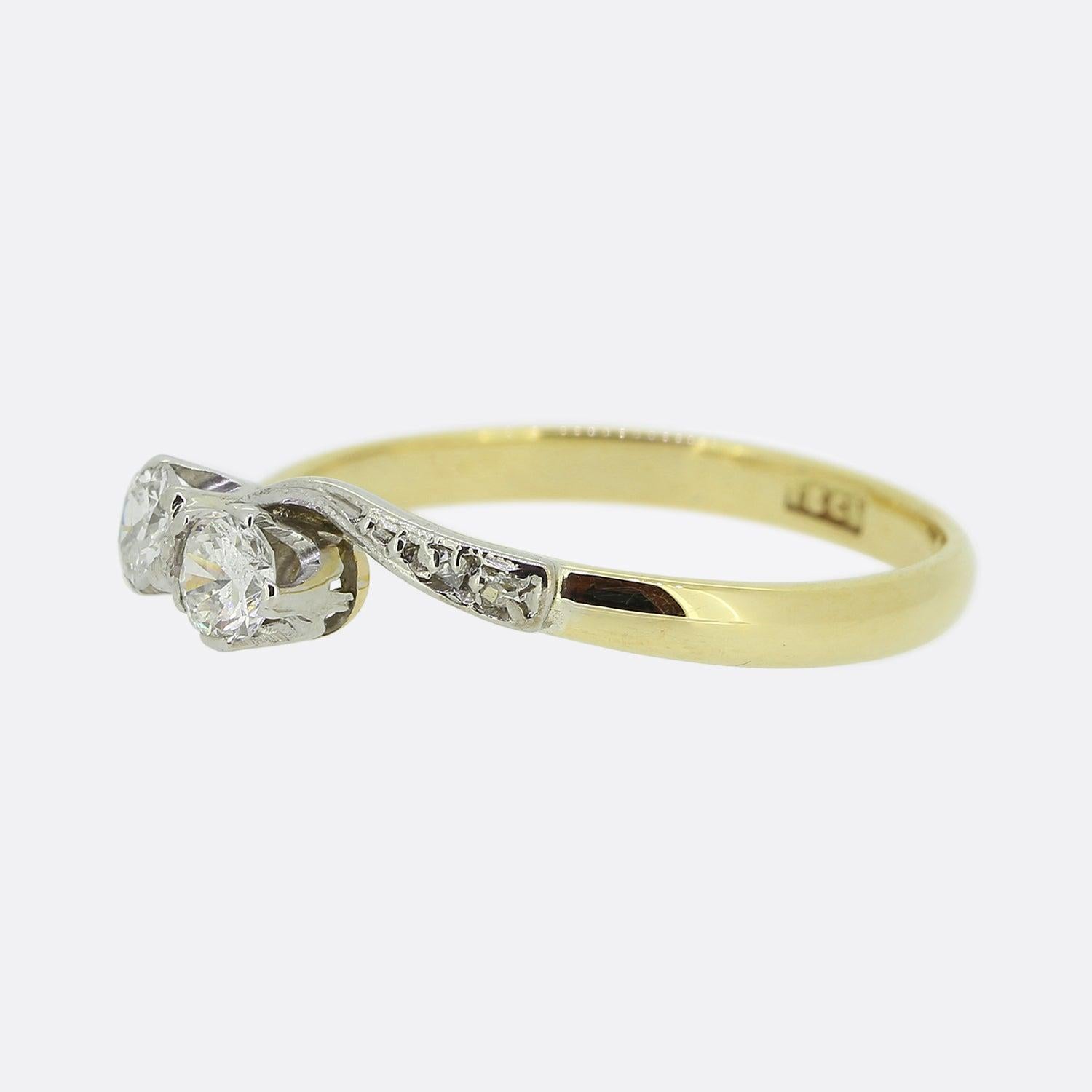 Ecco un anello crossover con diamante vintage. Due diamanti rotondi taglio brillante sono stati incastonati singolarmente a griffe in una leggera formazione diagonale. Queste pietre principali si trovano su spalle in platino con diamanti taglio rosa