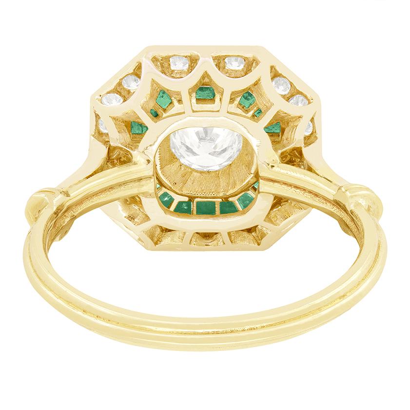 Cette superbe bague Vintage By est d'une grande beauté. Au centre, un diamant rond brillant de 0,40 carat est maintenu dans une monture à griffes sécurisée. Le diamant est entouré d'un halo envoûtant d'émeraudes vibrantes, d'une valeur totale de