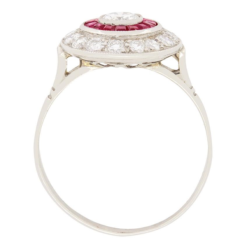 Este anillo único de diamantes y rubíes se fabricó en la década de 1950. En el centro se asienta un diamante brillante redondo de 0,40 quilates. El diamante engastado es de color F y claridad Si1. Alrededor de esta piedra central se sitúa un anillo