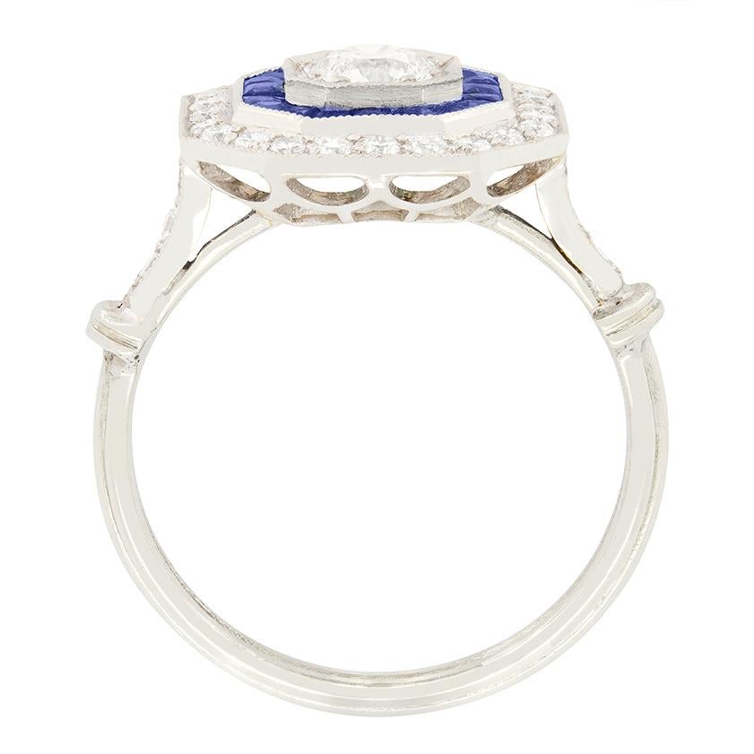 Questo splendido anello Vintage By è una vera bellezza. Al centro, un diamante tondo brillante da 0,40 carati è incastonato in una sicura montatura a griffe. Il diamante è circondato da un'affascinante aureola di zaffiri, per un totale di 0,60