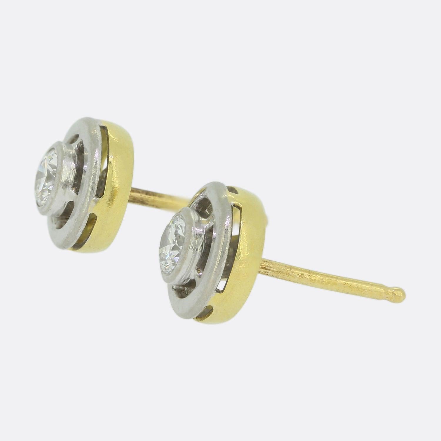 These are a pair of vintage 18ct yellow gold diamond stud earrings. Each earring features a 0.25 carat round brilliant cut diamond. Although the back of the earrings and posts are 18ct yellow gold the diamonds sit in a white gold rub-over mount to
