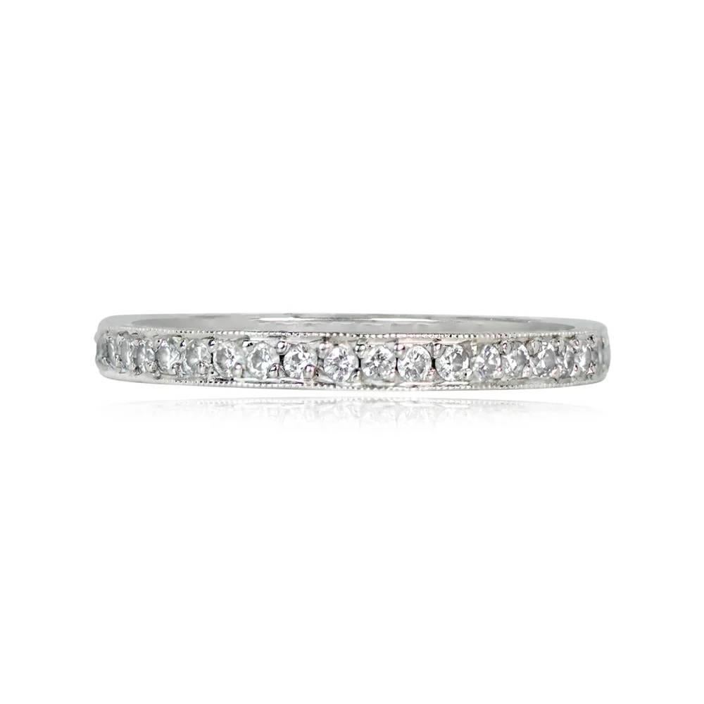 A vintage wedding band showcasing an eternity of pave-set round brilliant-cut diamonds with a total weight of approximately 0.50 carats, I color, and VS2 overall clarity. Crafted in platinum, the band is adorned with hand engravings on the sides and