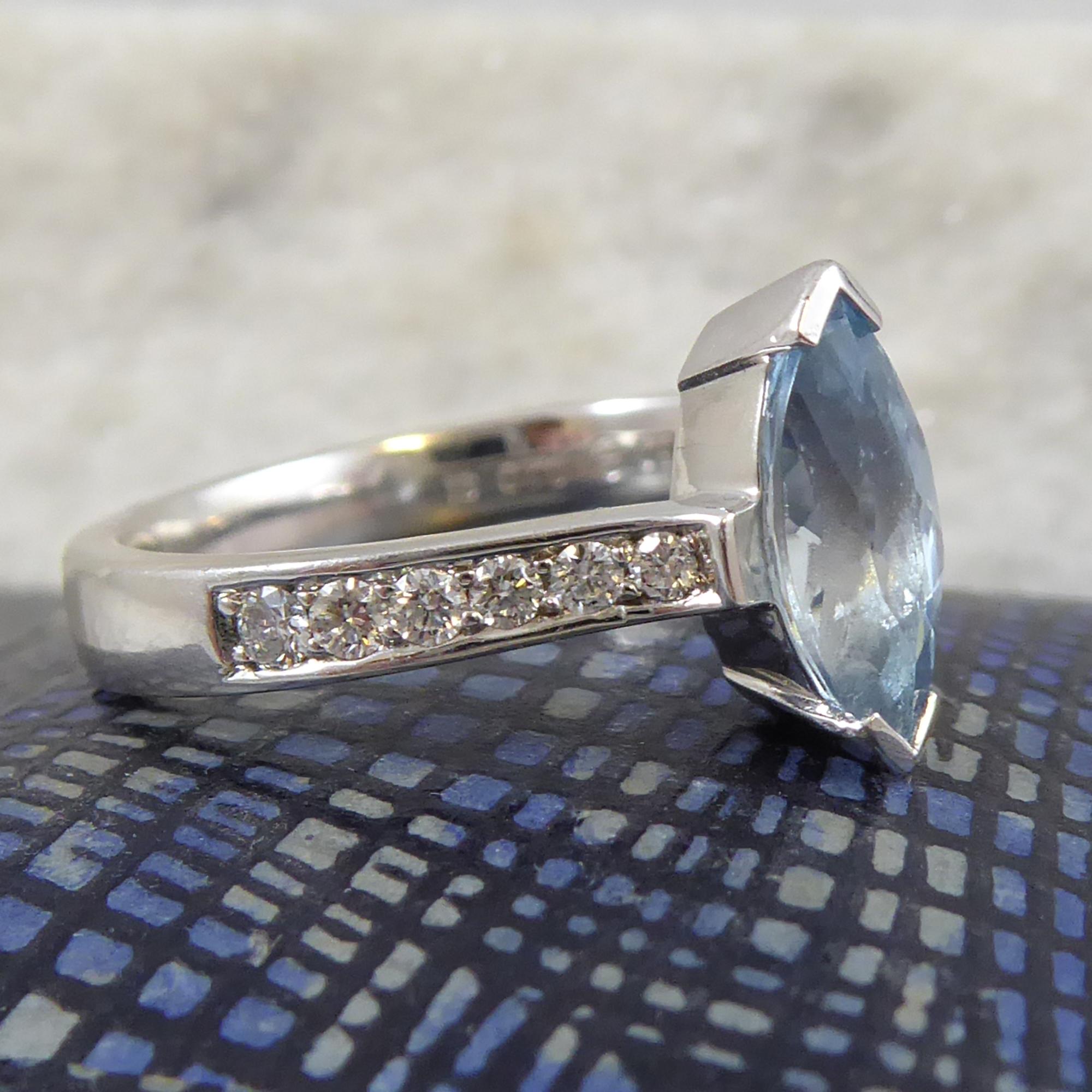 Beauiful mid-blue aquamarine cut in a marquise shape and mounted in part rub-over white gold setting.  Shoulders each set with six brilliant cut diamonds in a channel setting.  White band with slight D shaped profile.  Hallmarked 18ct white gold. 