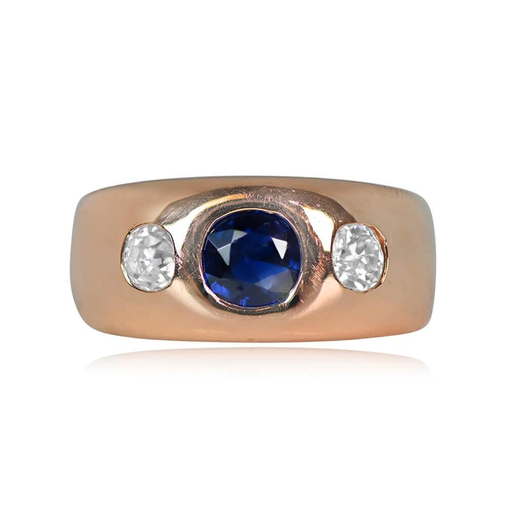 A vintage gypsy ring with a natural sapphire center stone weighing about 0.57 carats. Two old mine-cut diamonds, approximately 0.15 carats each, adorn each side of the sapphire. Crafted in 18k yellow gold around 1965, this ring carries French