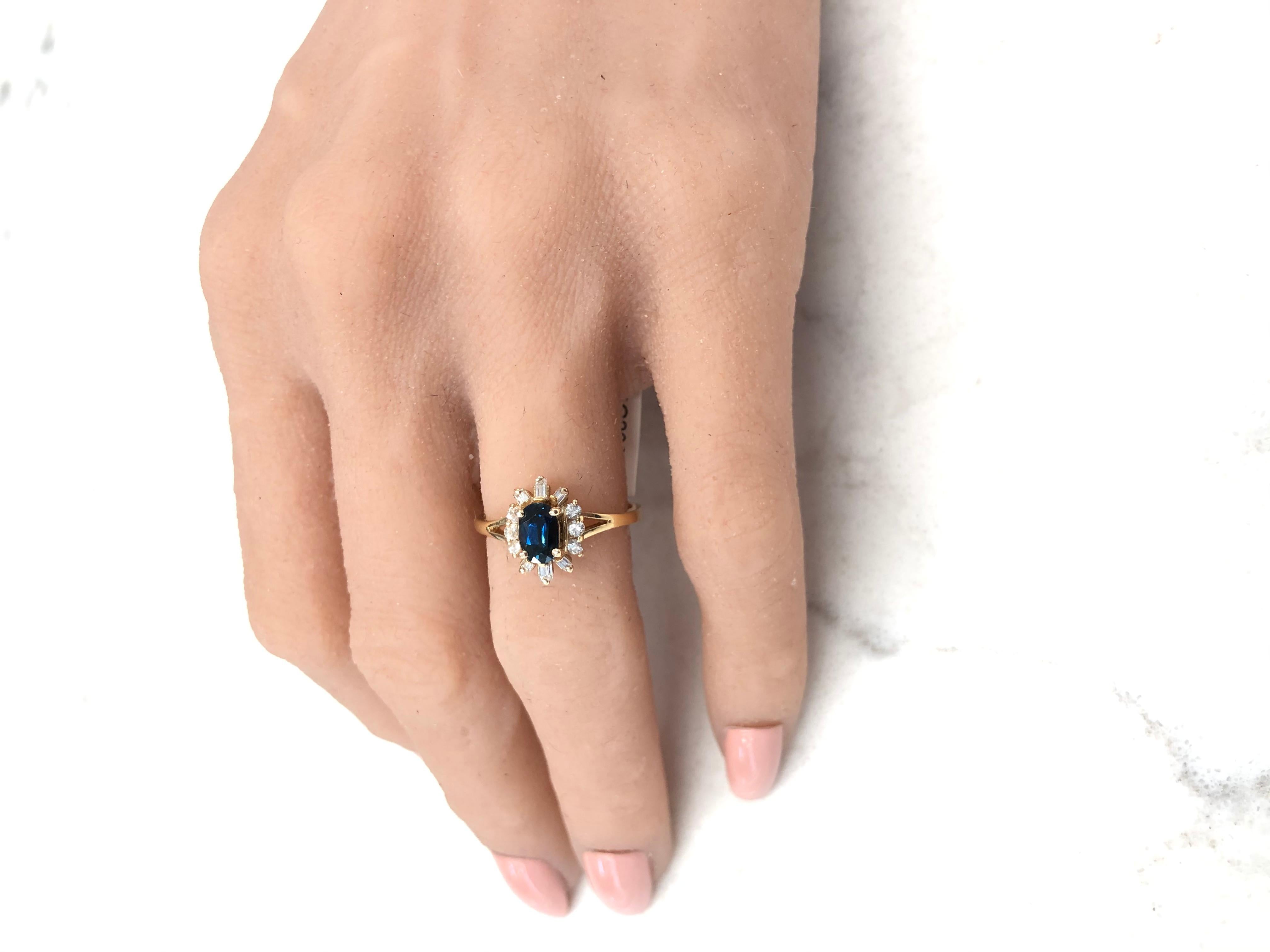 This brightly polished 14 karat yellow gold cocktail ring features a 0.59 carat sapphire in the center that exhibits an intense blue hue with overall excellent color saturation. This sapphire is complemented by 0.31 carats of round brilliant and
