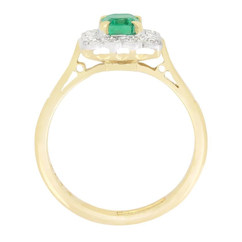 Dieser wunderschöne Ring aus den 1950er Jahren zeigt in der Mitte einen leuchtenden Smaragd von 0,60 Karat. Der Stein im Smaragdschliff ist in 18 Karat Gelbgold gefasst und von runden Brillanten von insgesamt 0,28 Karat umgeben. Jeder Diamant