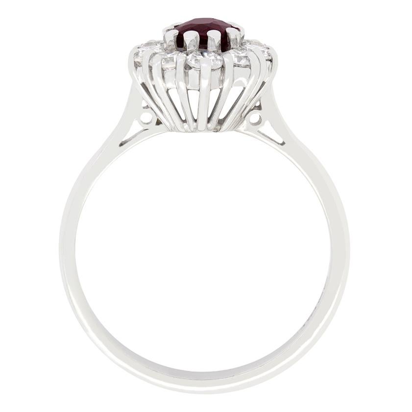 Cette charmante bague Vintage By s'articule autour d'un rubis d'un rouge profond. Le rubis de 0,60 carat est une pierre de taille ovale sertie dans de l'or blanc 18 carats. Le rubis est entouré d'un total de 1,00 carat de diamants taillés en huit,
