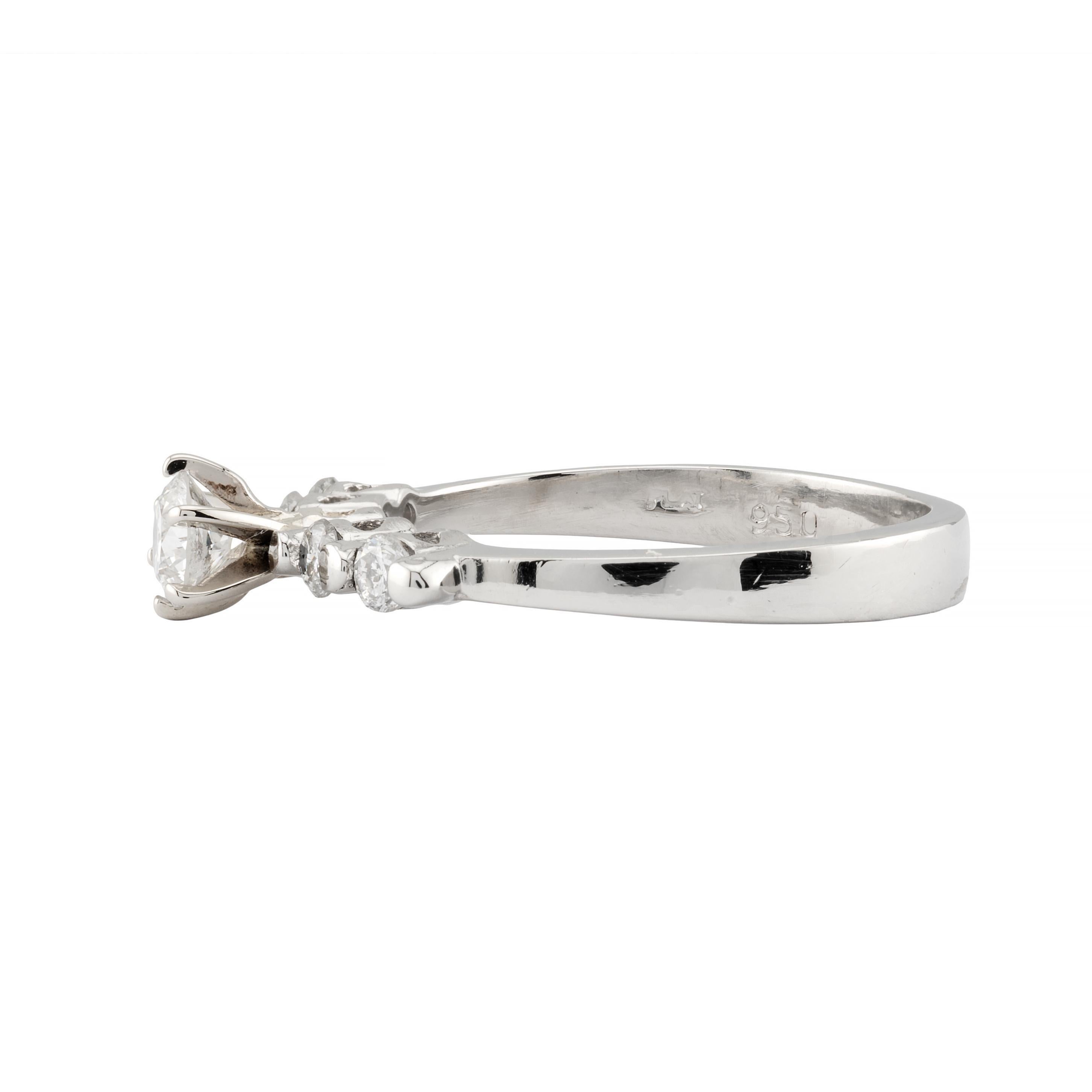 Aston Estate Jewelry Presents:

A vintage diamond engagement ring in platinum accented by pierced heart motifs. Centered by a 0.40 carat round brilliant cut natural diamond of G color with VS clarity.  Accented by four round brilliant cut diamonds