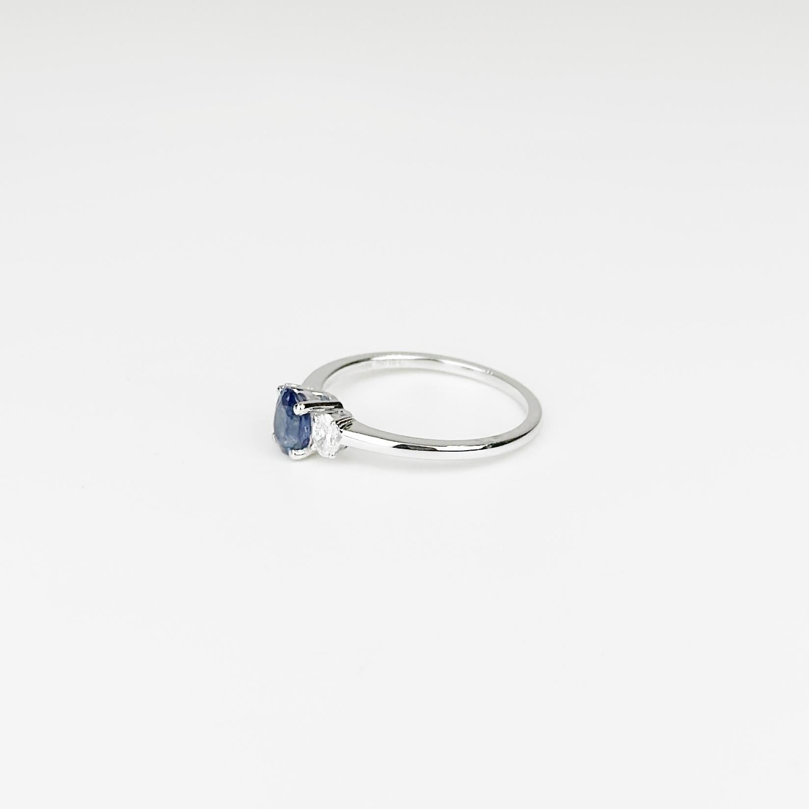 Questo elegante anello in oro bianco 18 carati mette in mostra uno splendido zaffiro dello Sri Lanka da 0,69 carati, rinomato per la sua profonda e ipnotica tonalità blu. Affiancati su entrambi i lati da due splendidi diamanti per un totale di 0,17
