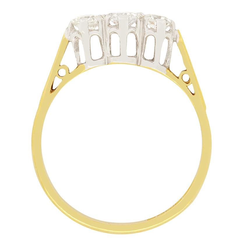 This 1970s ring was made in petite proportions to centre a round brilliant cut diamond between a pair of slightly smaller diamonds. The centre diamond weighs 0.30 carat, whilst the two flanking are both 0.20 carat. This brings the total weight to