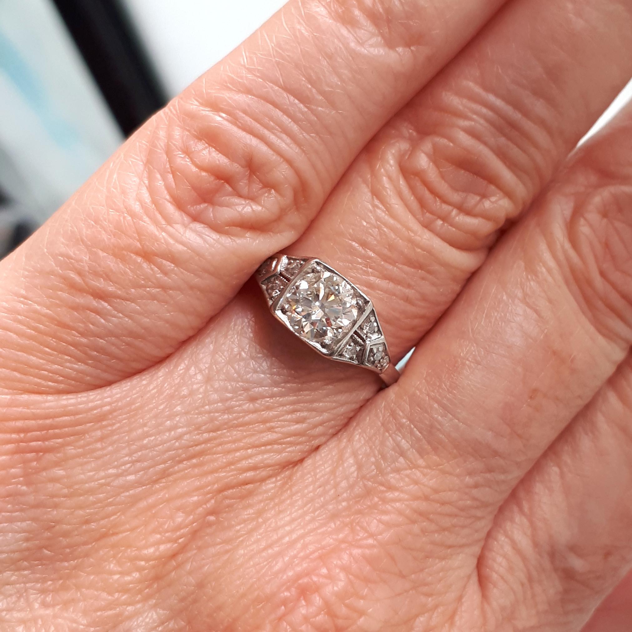 A vintage diamond ring, set with a round brilliant-cut diamond in the centre, weighing approximately 0.80ct, with four eight-cut diamonds in each shoulder, mounted in platinum, circa 1940.

Finger size UK Q ¼ / US 8.