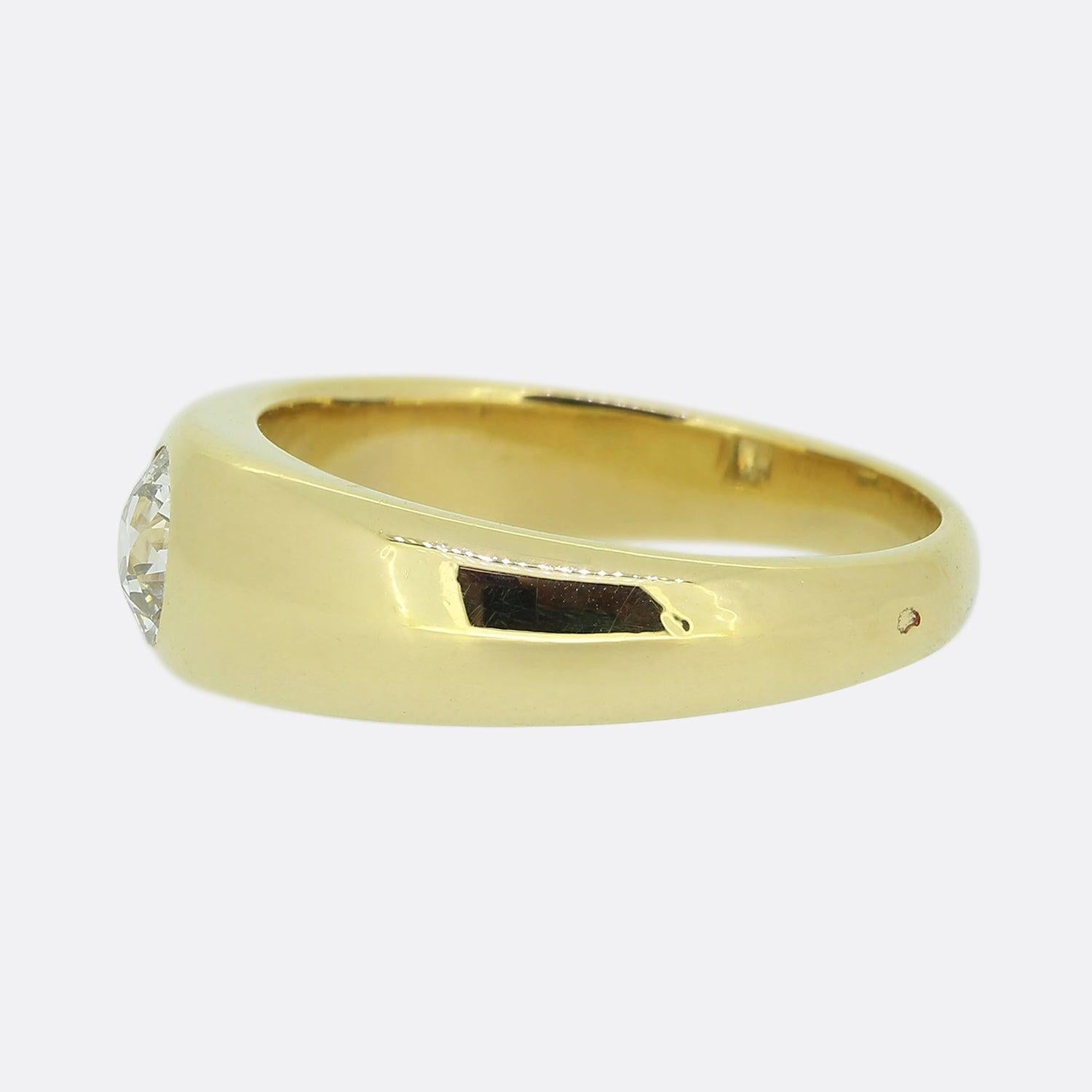 Here we have a classic single stone diamond ring. A rich 18ct yellow gold band with a wide face plays host to a single round faceted old mine cut diamond. This bright white stone sit alone at the centre in a rub-over setting atop a high polish