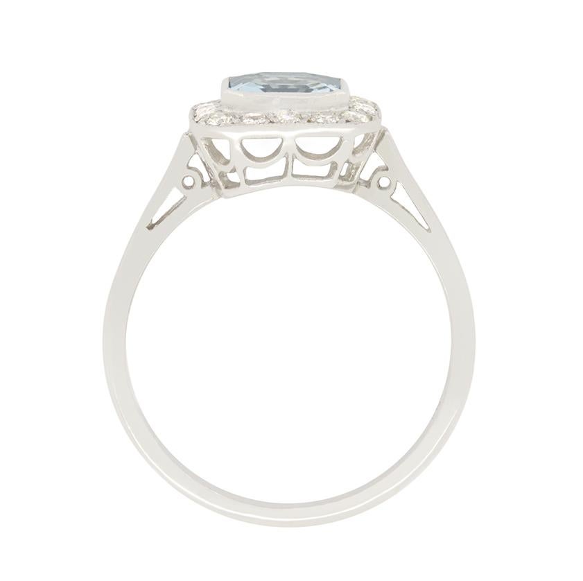 A pale blue Aquamarine is enveloped by diamond in this wonderful 1960s cluster ring. The Aquamarine is an asscher cut stone weighing 0.80 carat. Rub over set into platinum the beautiful gem is then surrounded by a total of 0.30 carat in round