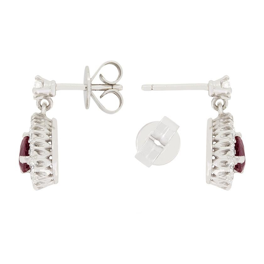 Los pendientes Vintage de rubíes y diamantes presentan un hermoso diseño con rubíes centrales engastados en garra de 0,40 quilates cada uno en talla pera. Rodeando a los rubíes hay diamantes brillantes redondos de 0,50 quilates en total en cada