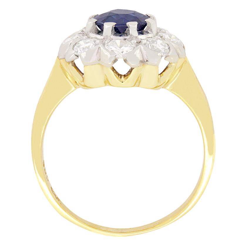 Dieser Vintage-Ring mit Saphiren und Diamanten stammt aus den 1950er Jahren und zeigt in der Mitte einen tiefblauen Saphir im Altschliff. Der Saphir in Krallenfassung ist ein altgeschliffener Stein und wiegt 0,80 Karat. Um den auffälligen Saphir