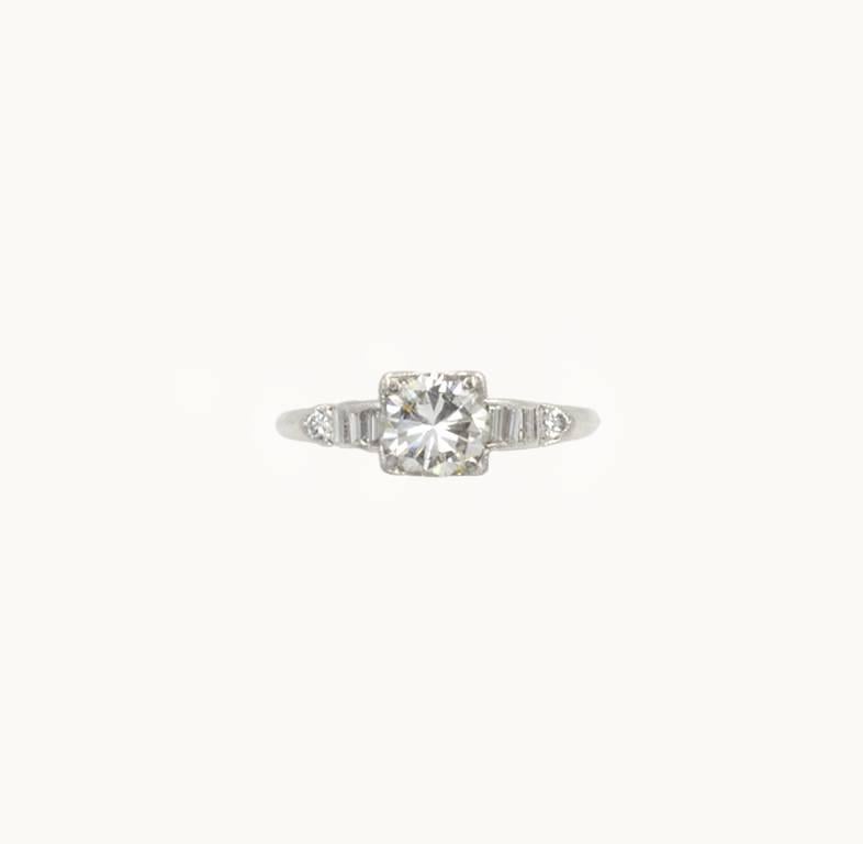 A beautiful vintage diamond and platinum engagement ring from circa 1950s.  This ring features a 0.84 carat round brilliant cut diamond that is I in color and SI2 in clarity (per EGL certificate).  The center round diamond is set in a square