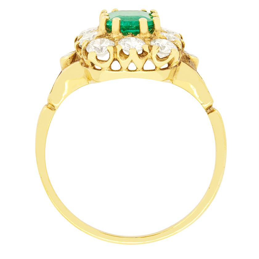 Ein wunderschöner Smaragd von 0,85 Karat ist der Stolz dieses Vintage-Cluster-Rings. Der Smaragd ist ein völlig natürlicher Stein mit einer lebhaften Färbung. Um den Smaragd herum sind insgesamt 1,00 Karat Diamanten im Altschliff angeordnet, die den