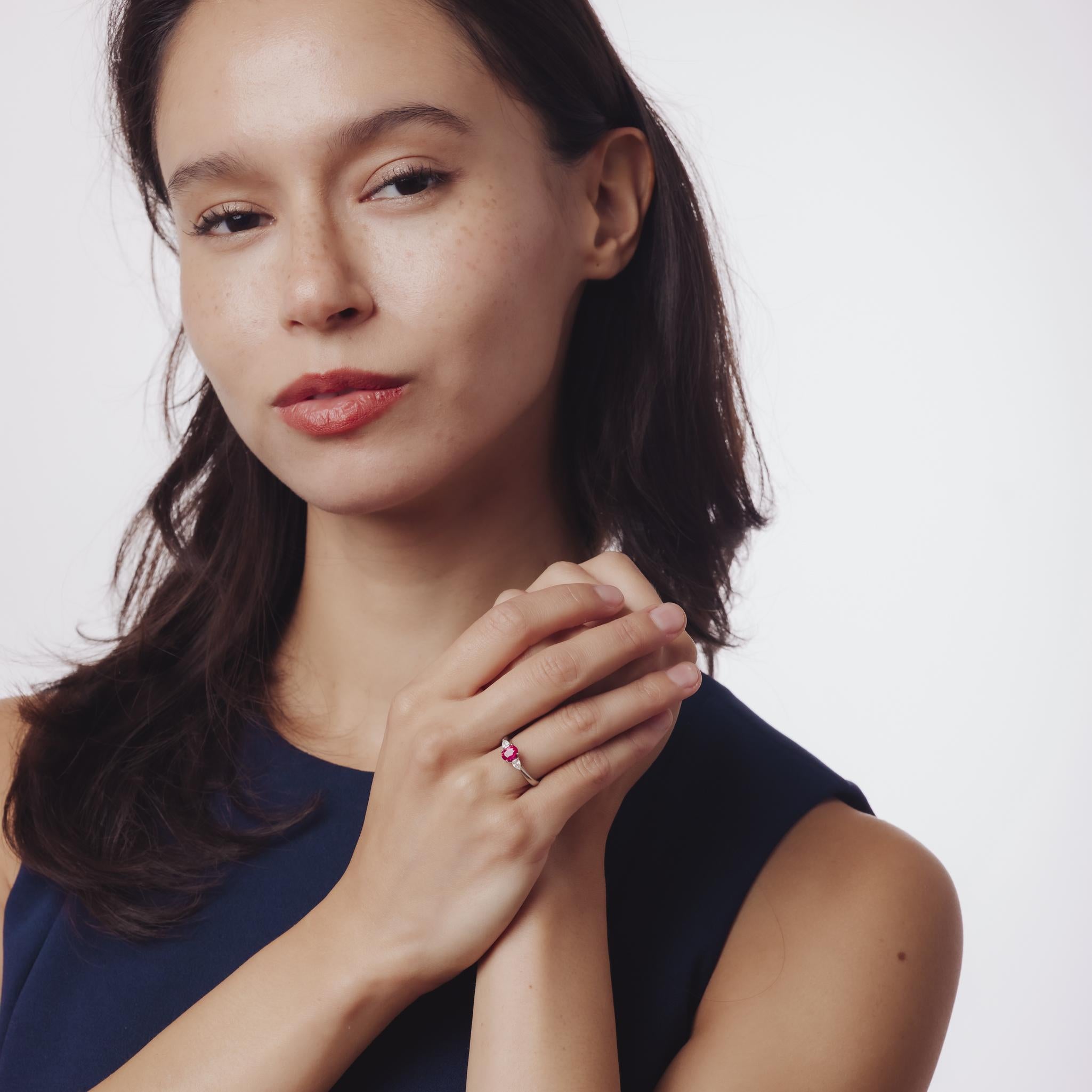 Cette élégante bague vintage en platine met en valeur un rubis ovale de 0,86 carat rehaussé de deux diamants poire étincelants, alliant couleur intemporelle et symétrie gracieuse.