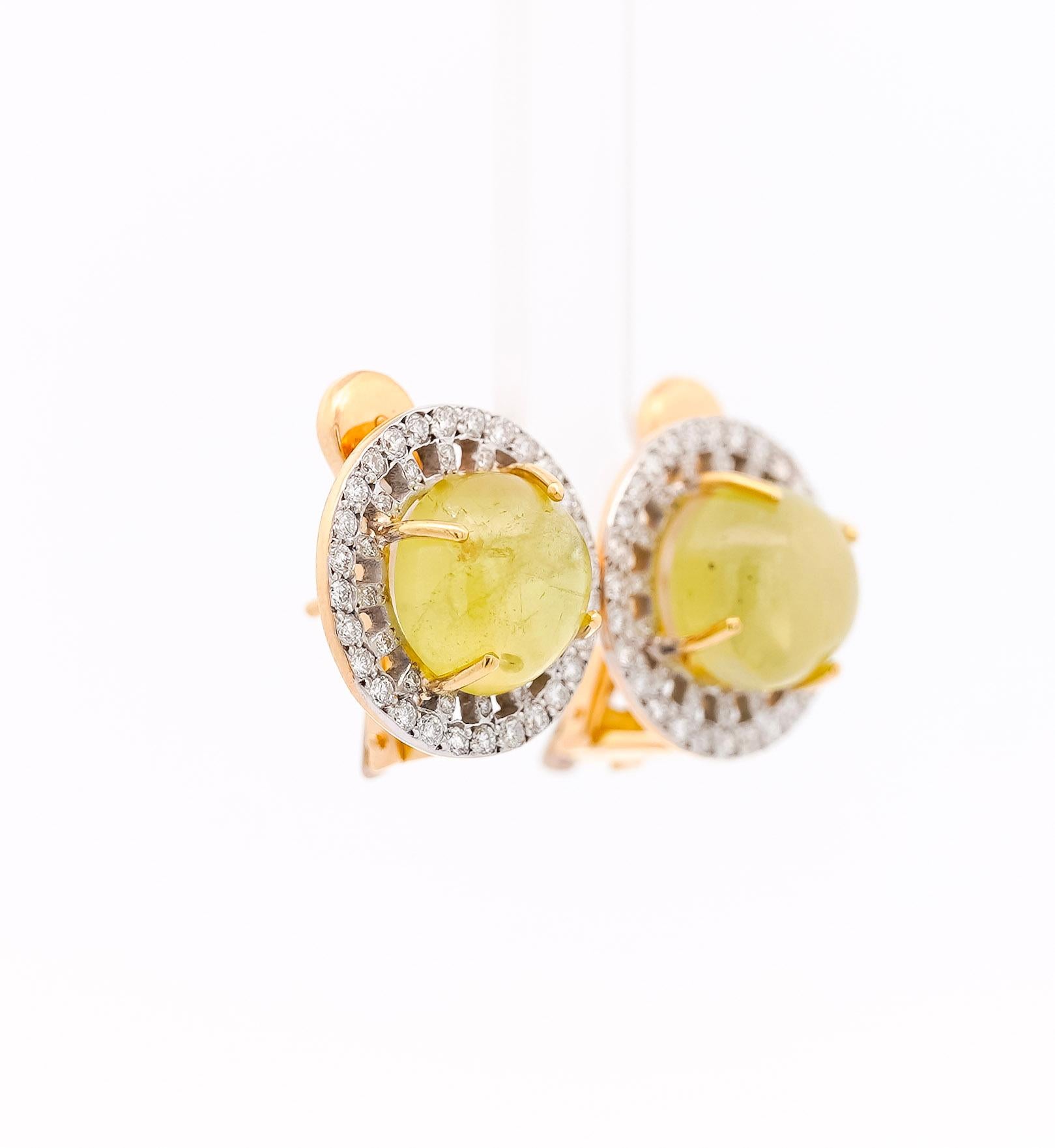 Crafted in 18K yellow gold, these earrings showcase a 10-carat total weight of captivating greenish-yellow chrysoberyl. Each 9mm cabochon-cut gemstone shimmers with a unique color hue, framed by round-cut diamonds totaling 1.3 carats. Secured by