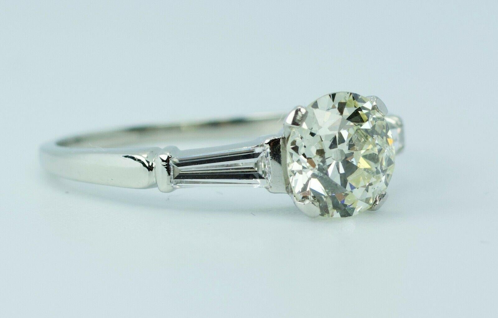 10% Iridium 90% Platinum Round European Cut Diamond With A Baguette Cut Diamond Ring
4.0 Grams
Ring Size 8.5
1 Round White European Cut Diamond 1.38 Carats 
Color: J 
Clarity: I1
2 Tapered Baguette Cut Diamonds 0.30 Carats Total Weight
Color: G