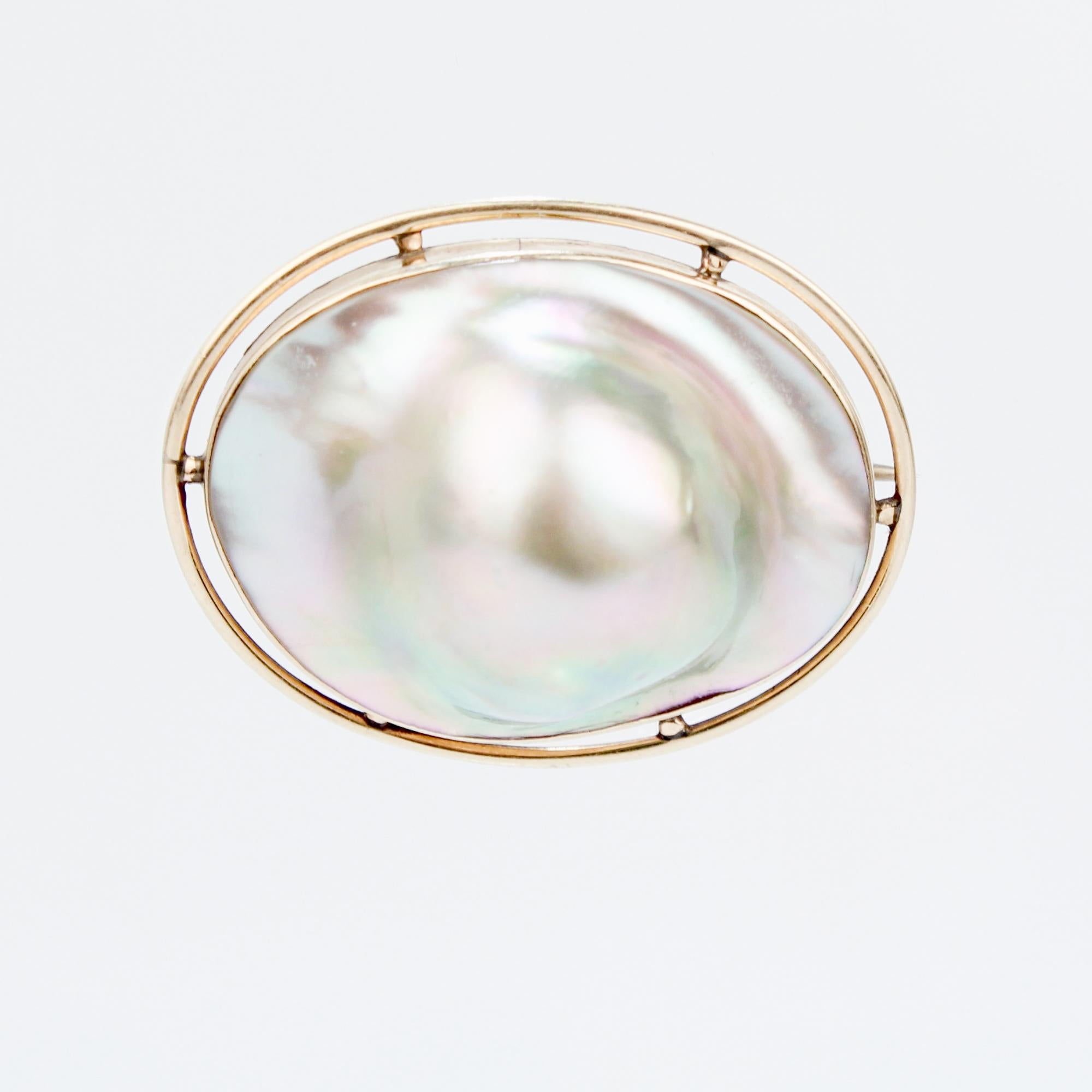 A fine vintage gold & blister pearl brooch.

Comprising a bulbous blister pearl in a circular gold setting.

With a pin and 'C' shaped catch to the reverse.

Simply a wonderful brooch!
 
Date:
Mid-20th Century

Overall Condition:
It is in overall