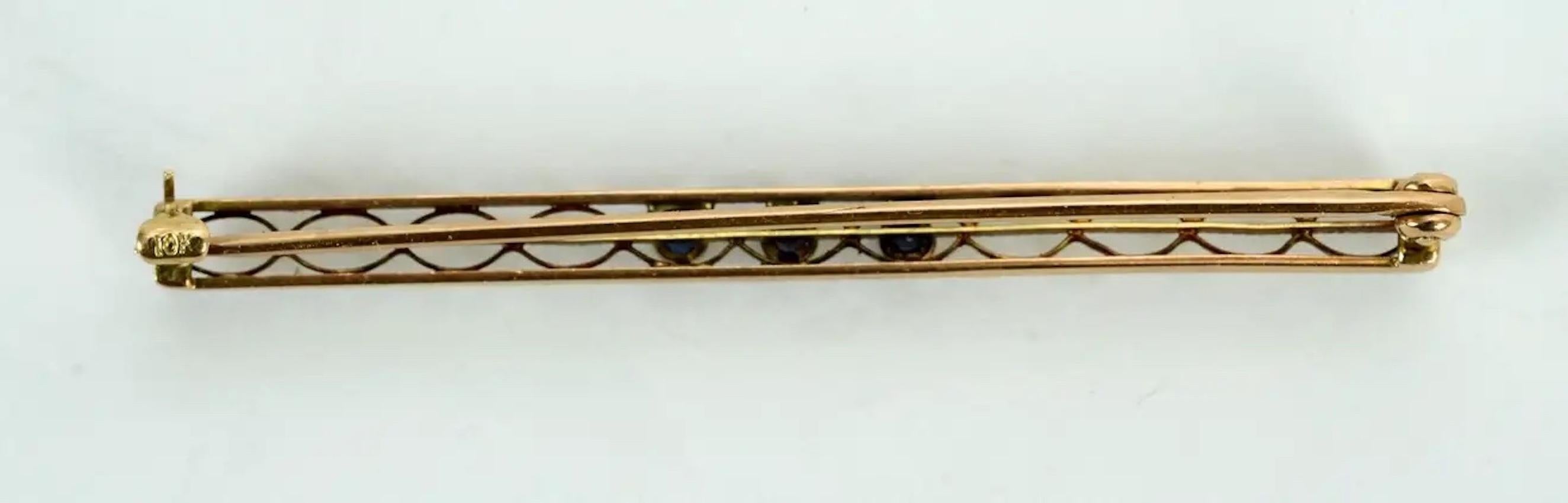 Vintage 10 Karat Yellow Gold, Diamond and Seed Pearl Bar Pin or Brooch. Early 20th c with a central 2.5mm full cut diamond set in a floral mount and a pair of 2mm seed pearls in a beautifully detailed, pierced and decorated frame, hallmarked 10K.