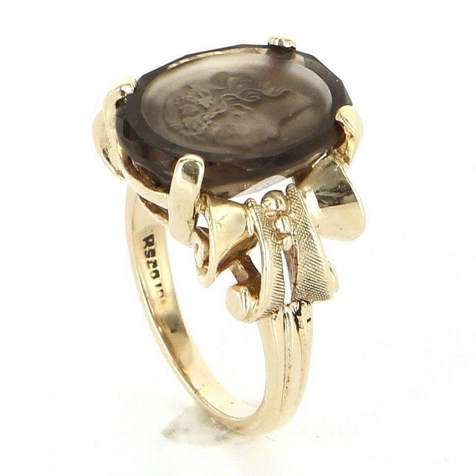 Offered for sale is a truly superb vintage cocktail ring, crafted beautifully in 10 karat yellow gold. 

Smoky quartz is an estimated 9 carats.

The intaglio cameo ring features the side profile of an elegant woman. 

A nice quality and finely made