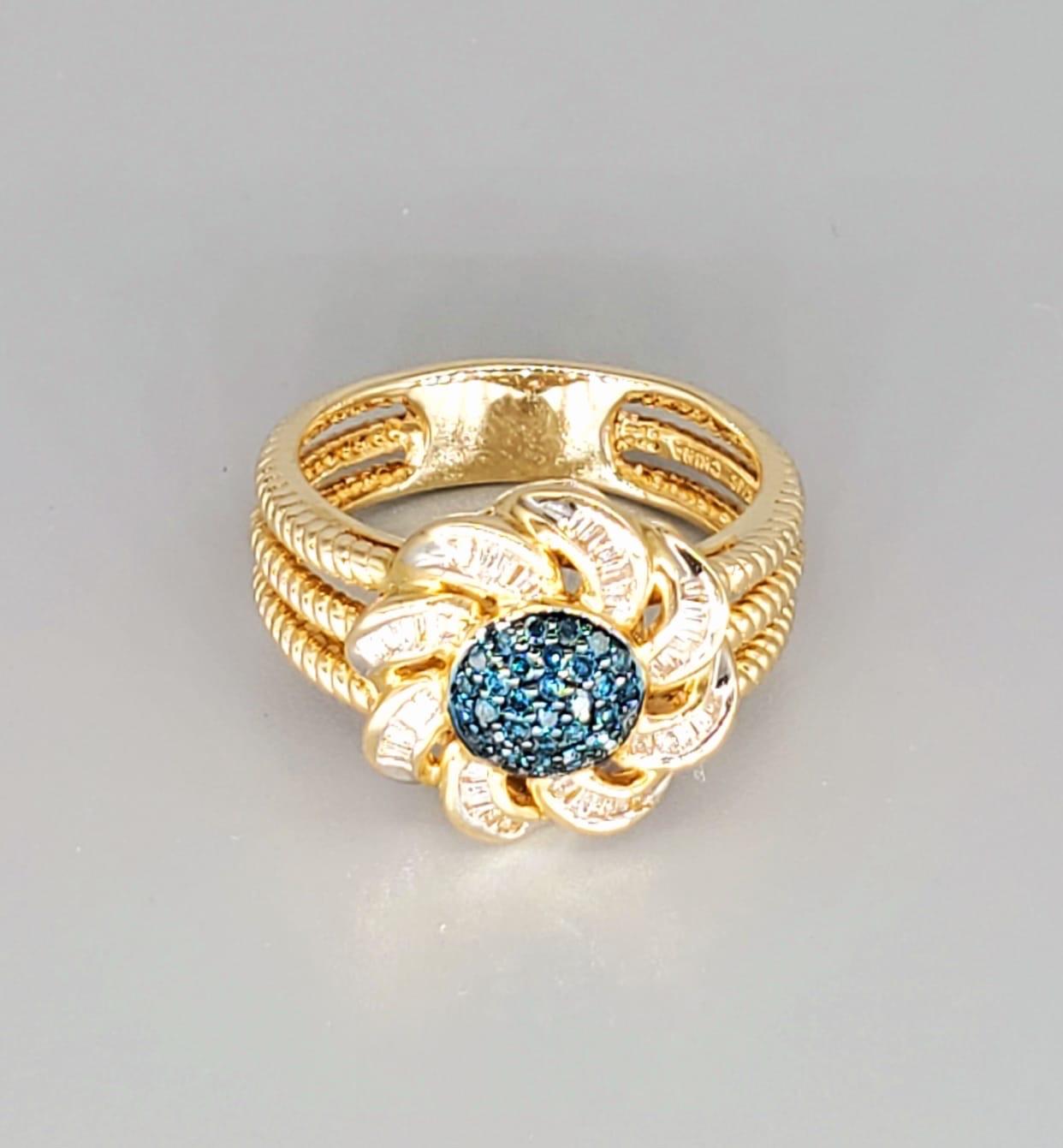 Vintage 1.00 Carat Diamonds Flower Cluster Ring. The ring is in excellent condition and feature blue diamonds in the center as well as surrounded by tapered baguettes on the leaves. The blue diamonds weight a total of approx 0.50 carats & the