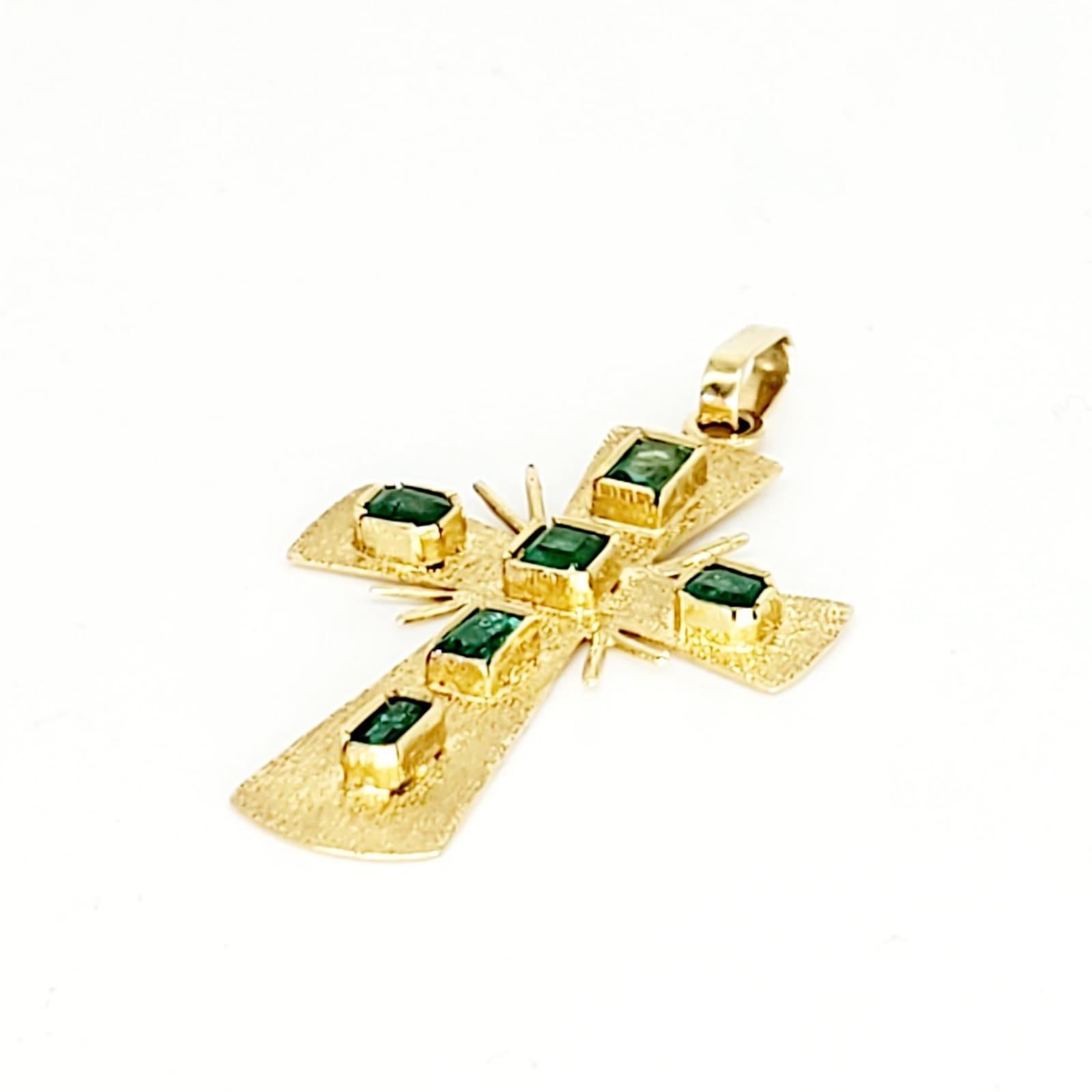 gold cross with emeralds