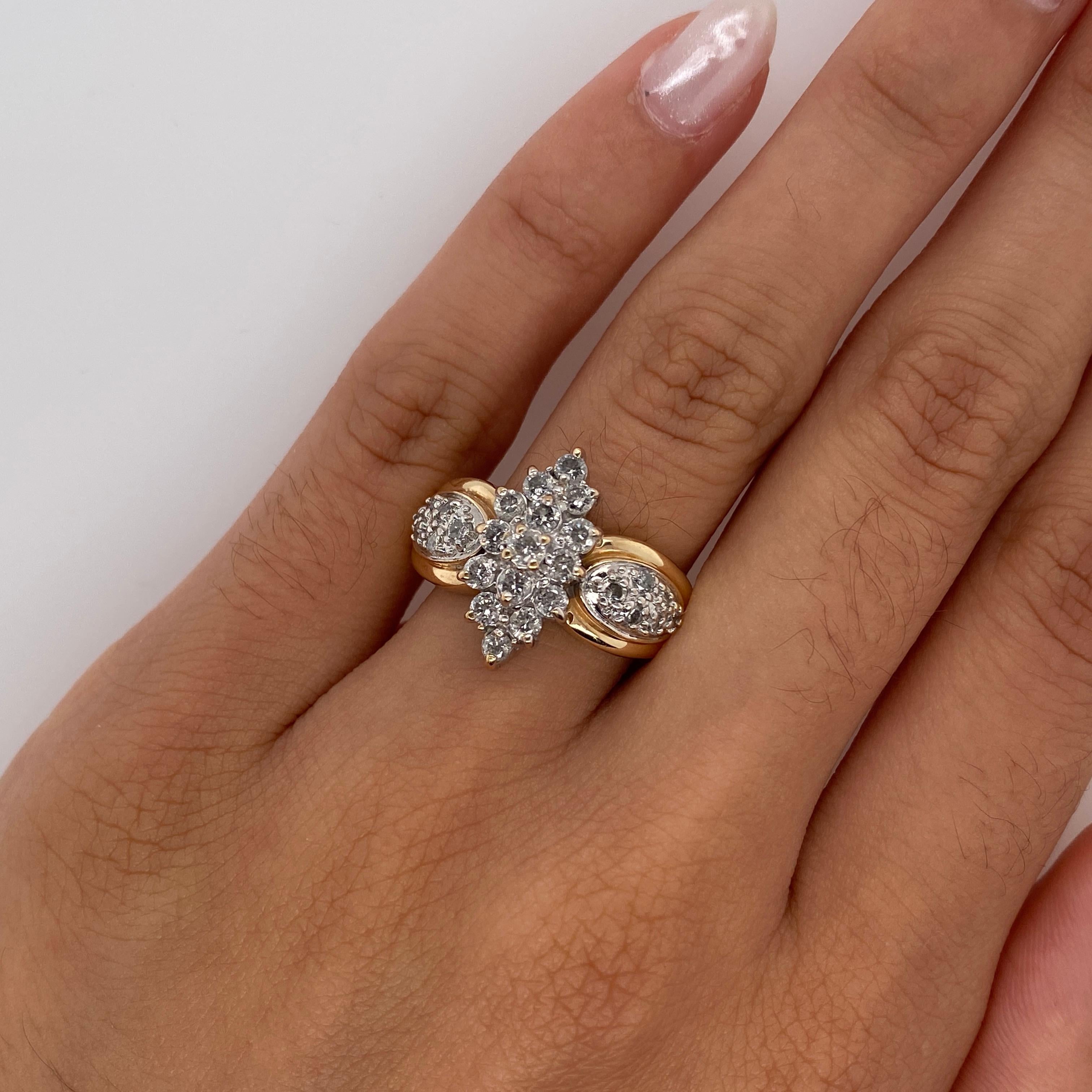 This is a vintage diamond cluster charmer! The center diamonds form a tall ship made of sparkles, and the side diamonds form oval pools to accent the center. The navette center of the ring is made in 14 karat white gold, while the ring band is made