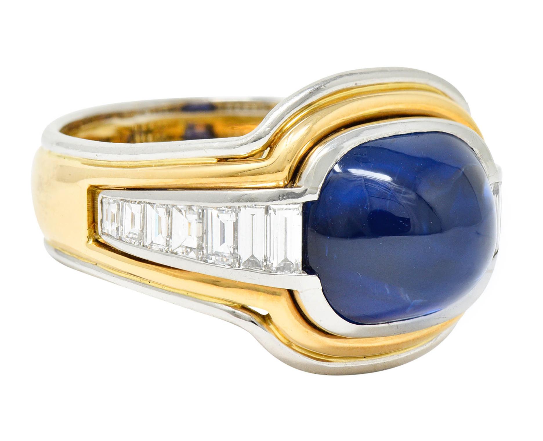 Centering a cushion cabochon sapphire weighing approximately 9.00 carats

Transparent with vibrant royal blue color

Bezel set in white gold and flanked by channel set baguette cut diamonds - graduating in size

Weighing in total approximately 1.00