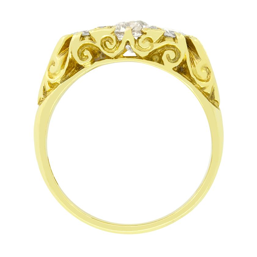 Questo meraviglioso anello in stile vittoriano mette in mostra un diamante centrale dal taglio antico, affiancato da diamanti tondi brillanti in una montatura a gambo intagliato. Il diamante centrale è di 0,60 carati, mentre la coppia di diamanti
