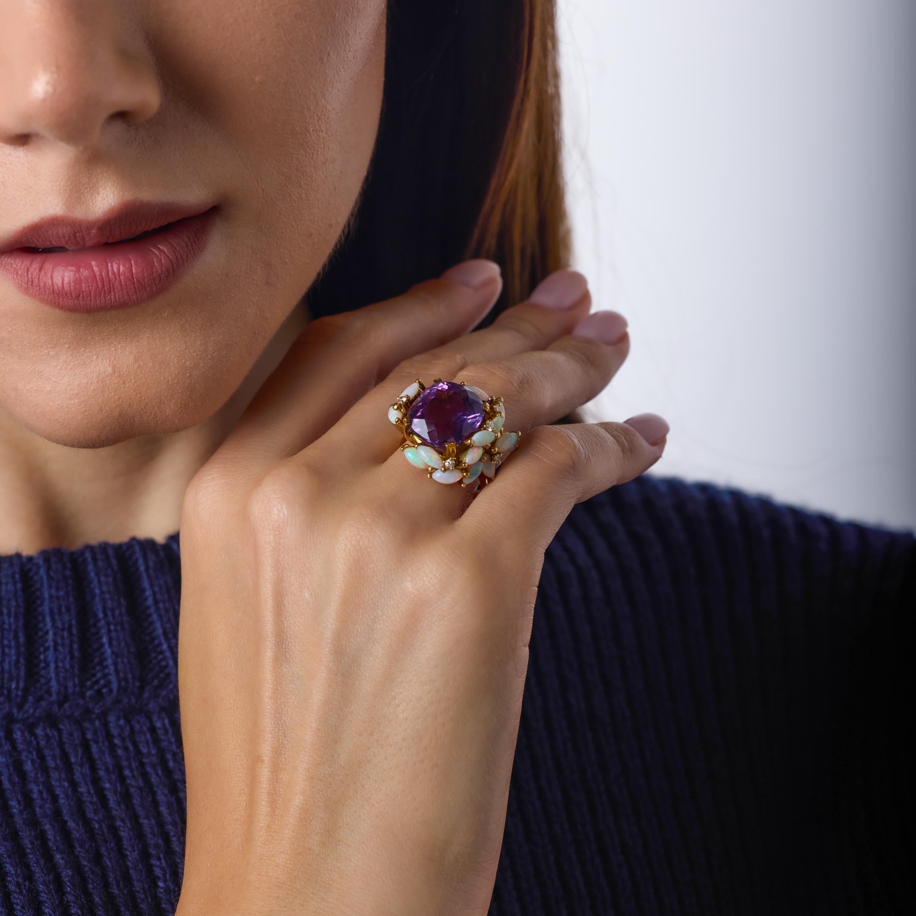 Questo anello da cocktail vintage è incentrato su una lussuosa ametista da 10,20 carati con taglio a cuscino, che risplende con una profondità ricca di sfumature Jewell. Intorno, gli opali taglio marquise brillano con un gioco di colori etereo,