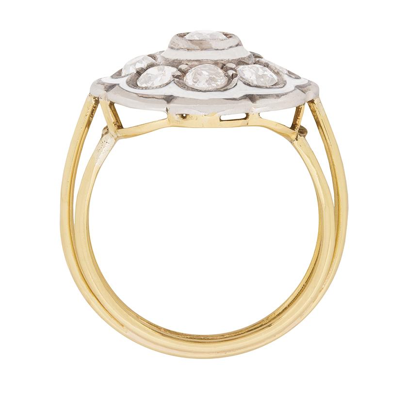 Trimmed with the original 1930s era enamel and millegrain edging, eight well-matched old cut diamonds are the petals to one slightly larger diamond at the centre of this daisy cluster ring. Tri-split shoulders leading to a fluted shank complete the