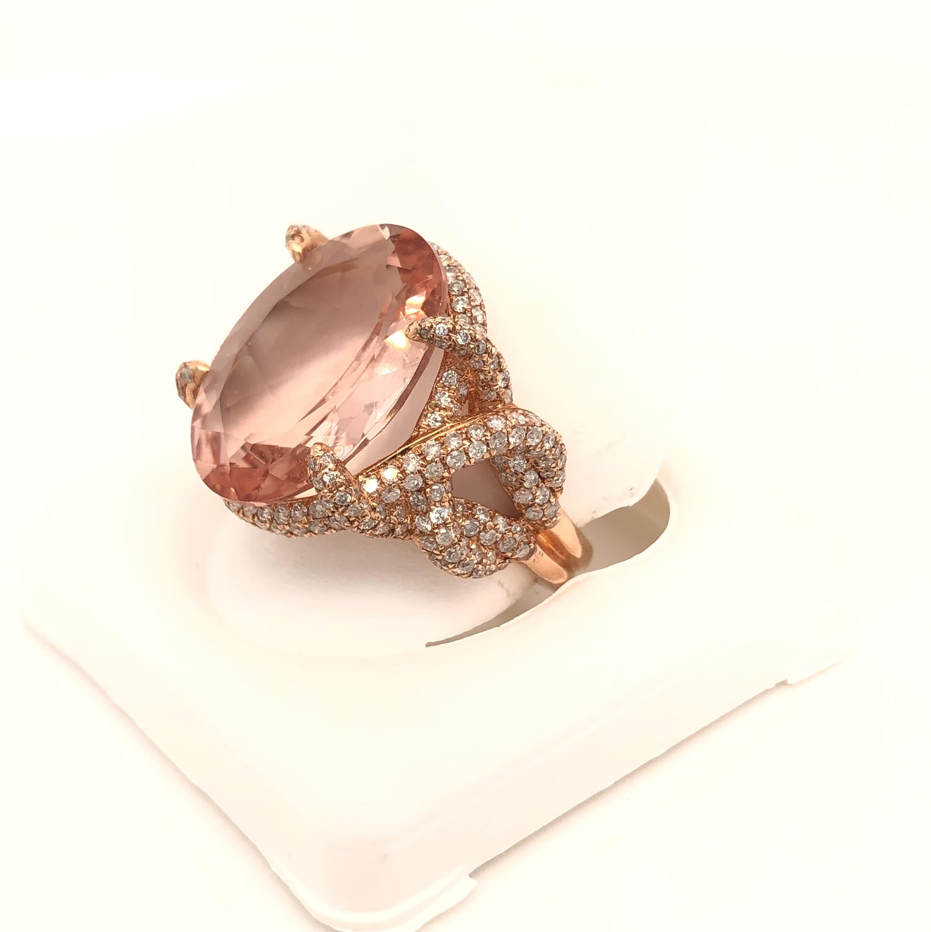 This is a magnificent natural morganite and diamond ring set in solid 14K rose gold. The natural 10.83 CT Morganite oval has an excellent peachy pink color and is set on top of a gorgeous diamond encrusted shank. The ring is stamped 14K and is a