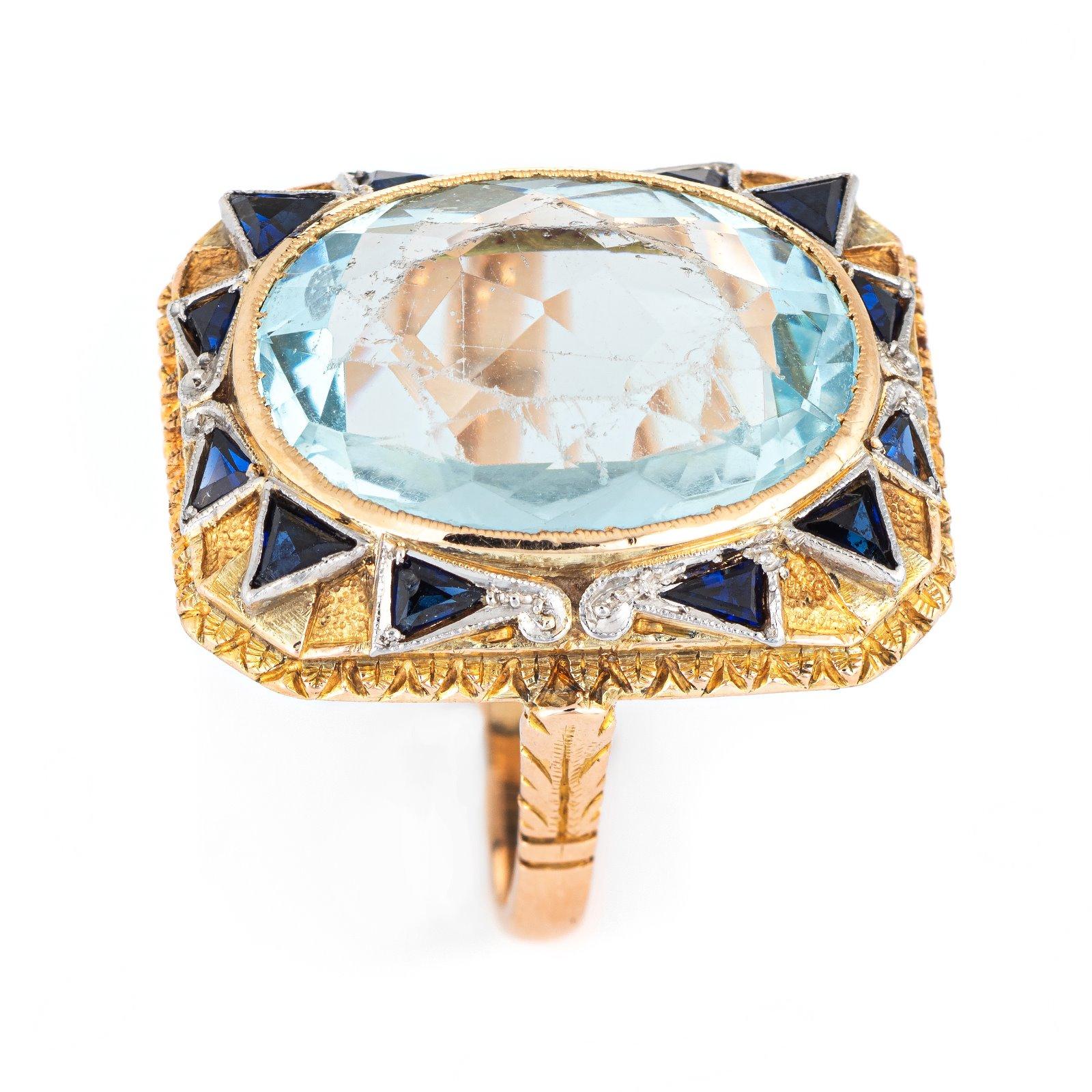 Stylish vintage aquamarine & sapphire cocktail ring (circa 1920s to 1930s) crafted in 18 karat yellow gold. 

Faceted oval cut aquamarine measures 18mm x 13mm (estimated at 10 carats), accented with 12 estimated 0.05 carat triangular cut sapphires