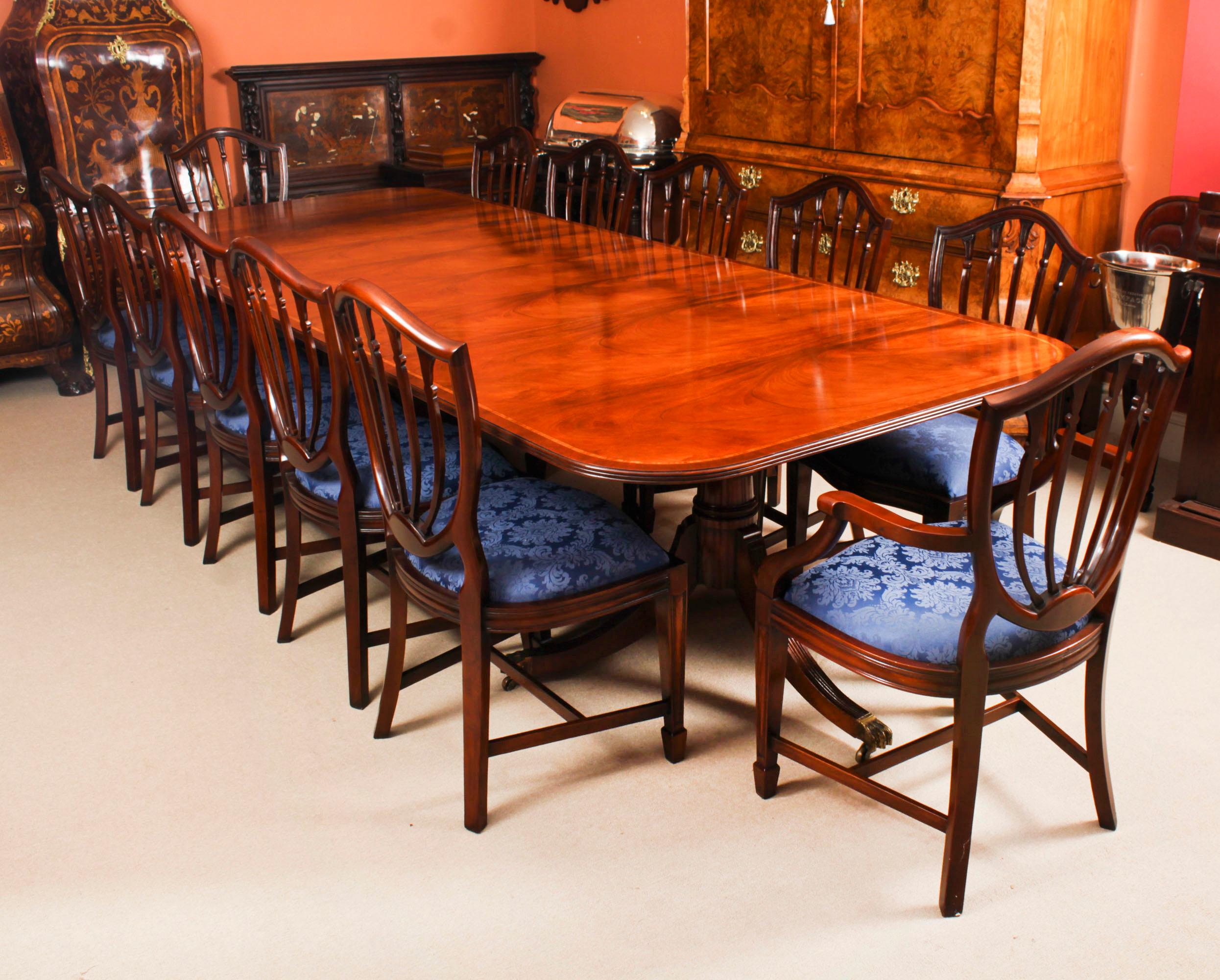 This is a superb large Vintage handmade double pedestal dining table in elegant George III style, by the master cabinetmakers Arthur Brett & Son, Norwich, crafted in flame mahogany with striking wood banding, numbered 761401 and dating from the mid