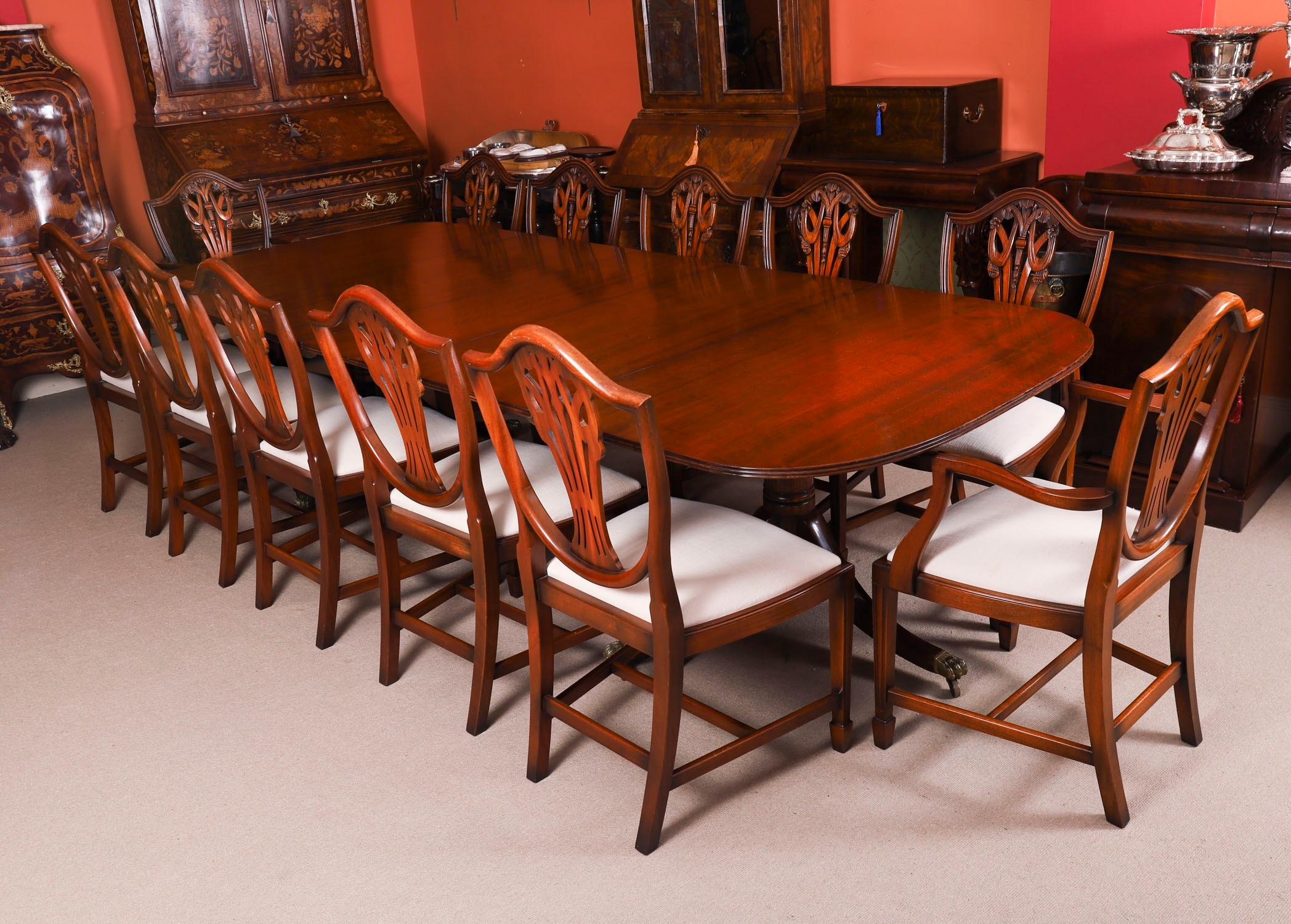 Il s'agit d'une superbe table de salle à manger à deux pieds, faite à la main, dans l'élégant style George III, en acajou et datant du milieu du 20e siècle.

Capable d'accueillir douze personnes dans un confort royal, il s'agit d'un meuble