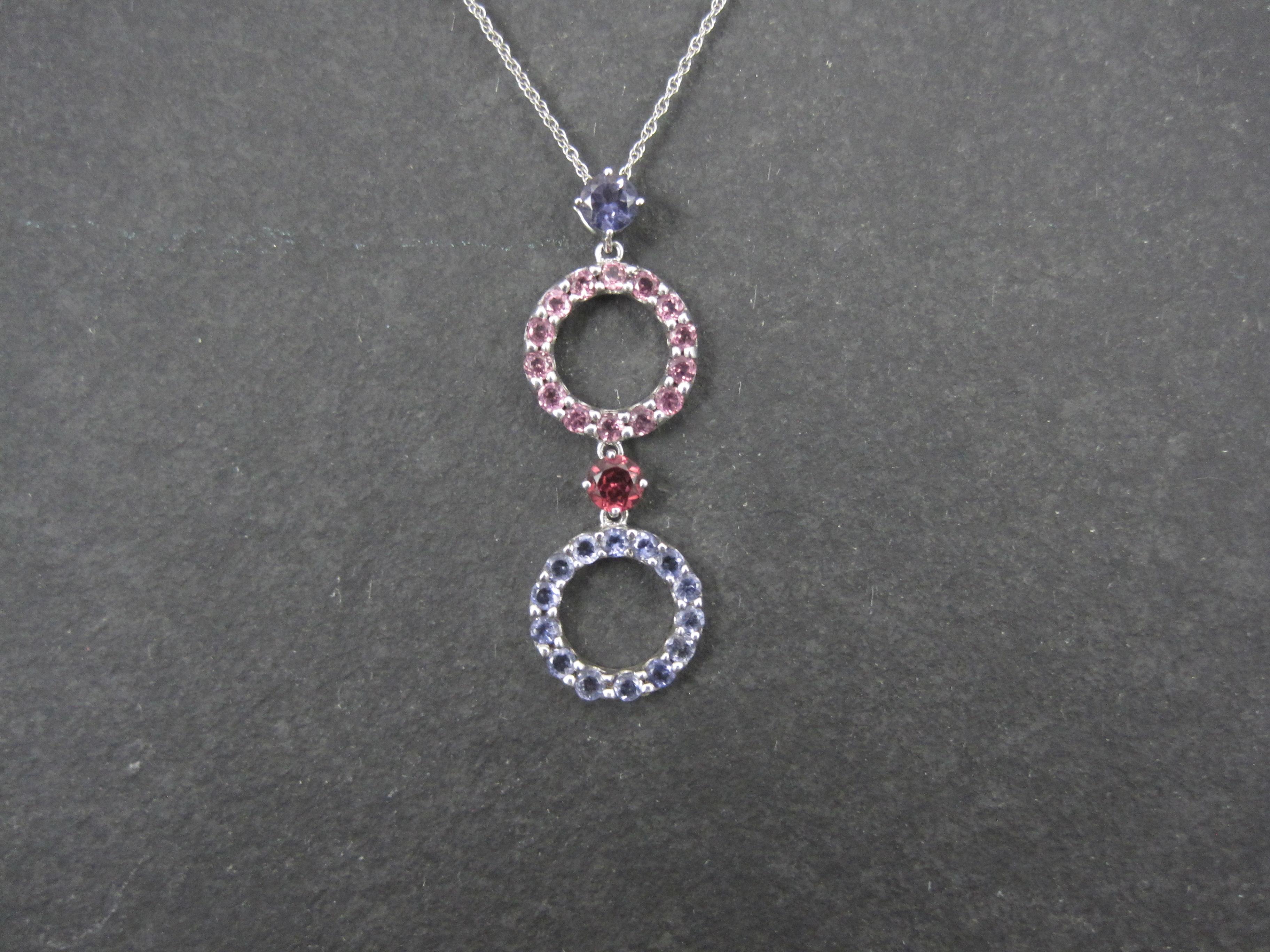 This beautiful pendant is 10k white gold.
It features a 4mm round cut iolite, a 4mm round cut pink tourmaline, an estimated .28 carats in round amethysts and an estimated .28 carats in round pink topaz.

Measurements: 1/2 by 1 7/16 inches

Comes on