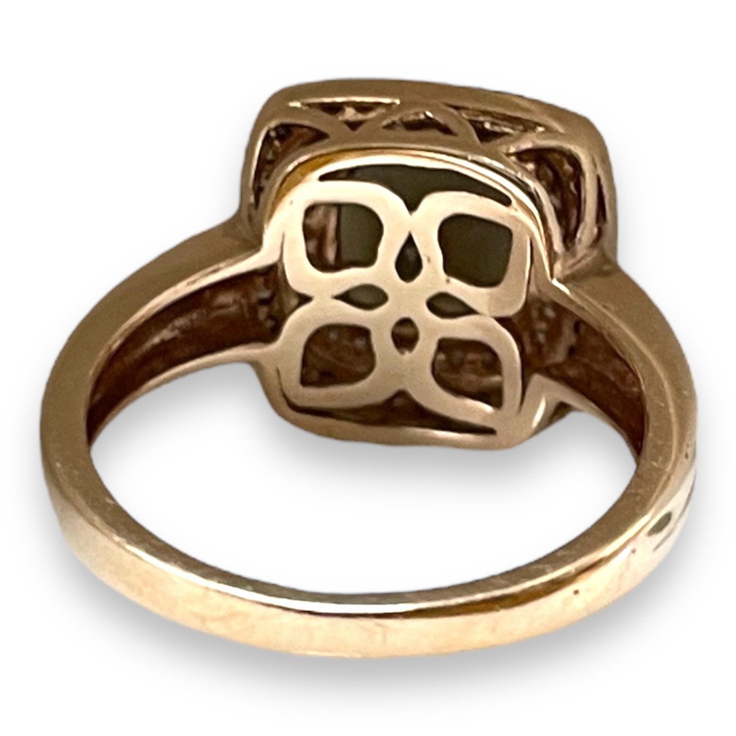 Eine Aura von Vintage-Eleganz umgibt diesen markanten Ring aus warmem Roségold. In seinem Herzen besticht ein reicher, tiefer Rauchquarz, der von einem Halo aus funkelnden Diamanten umgeben ist. Das filigrane Design unter dem Stein verleiht diesem