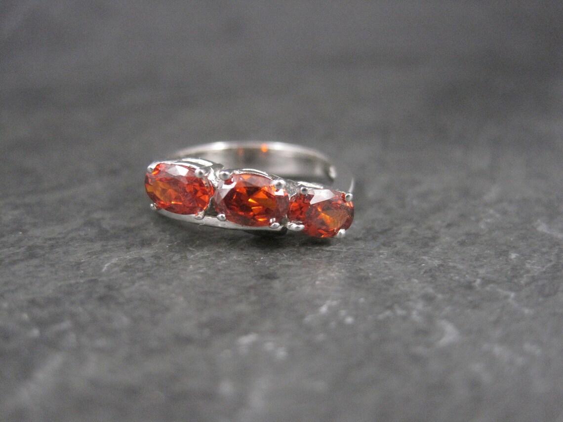 This gorgeous estate ring is 10K white gold with 3 oval cut 4x6mm garnet gemstones.

The face of this ring measures 1/4 of an inch north to south with a rise of 5mm off the finger.
Size: 6

Marks: 10K